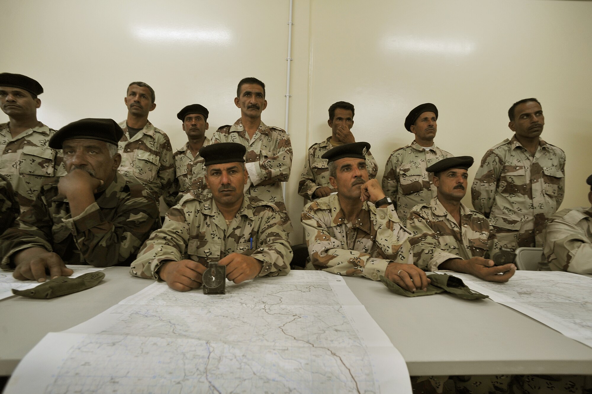 Iraqi Air Force Basic Training Top Off students sit and listen during a land-navigation class at the Iraqi Air Force Training School in Camp Taji, Iraq, April 18, 2010. The Iraqi airmen volunteered to return to active duty through the rehire program by the Ministry of Defense.   (U.S. Air Force photo/Staff Sgt Quinton Russ/released)