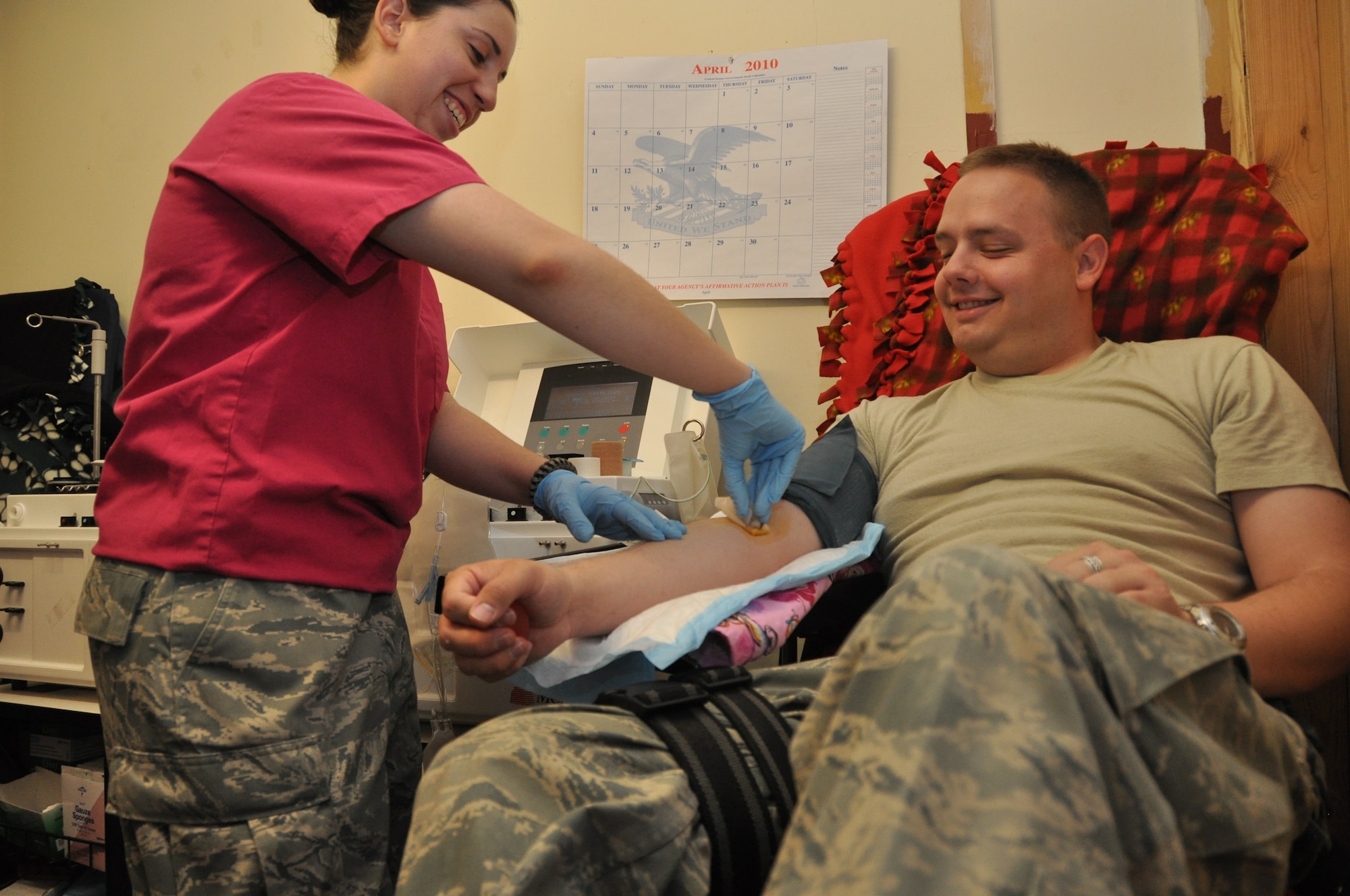 Staff Sgt. Monique Bell, apheresis laboratory technician, prepares Staff Sgt. Justin Mickelson, 451st Air Expeditionary Wing finance management craftsman, for platelet donation. (U.S. Air Force photo by Tech. Sgt. Renni Thornton/Released)