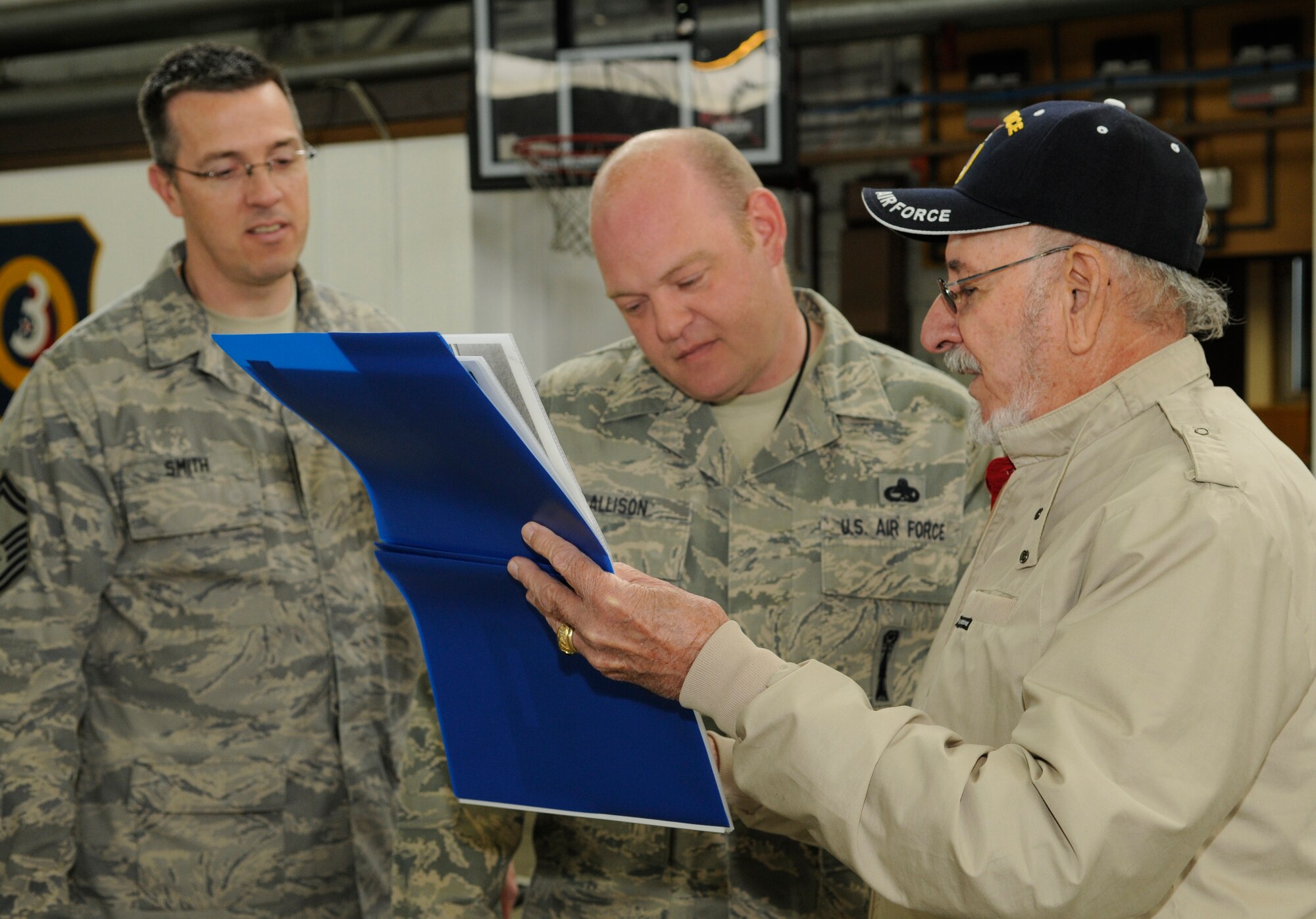 SPANGDAHLEM AIR BASE, Germany – Omar Garcia, right, flips through a book of photos with Master Sgt. Jason Allison, center, 52nd Maintenance Operations Squadron loading standardization crew chief, and Senior Master Sgt. Daniel Smith, left, 52nd MOS superintendent, during his visit here May 7. Mr. Garcia was the first crew chief to be stationed at Spangdahlem and worked on the L-5 Sentinel from 1951 to 1954. (U.S. Air Force photo/Senior Airman Benjamin Wilson)