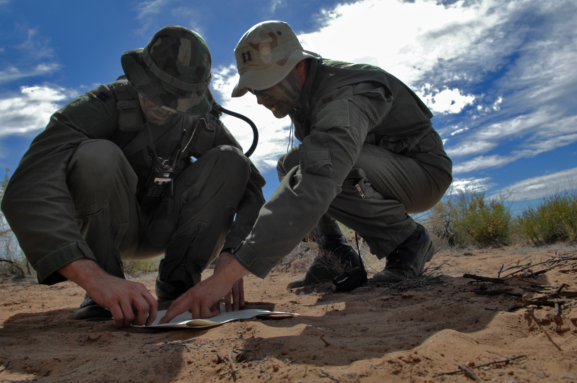 HOLLOMAN AIR FORCE BASE, N.M. -- Capt. Jeffrey Peterson and Capt. Bradley Young, 7th Fighter Squadron, plan their route of travel during Survival, Evasion, Resistance and Escape refresher training May 5, 2010. The pilots use a topographical map to plan their route and reach their contact point. Pilots and aircrew members are required to demonstrate competency in SERE techniques on a reoccurring basis. (U.S. Air Force photo by Airman 1st Class Joshua Turner / Released)