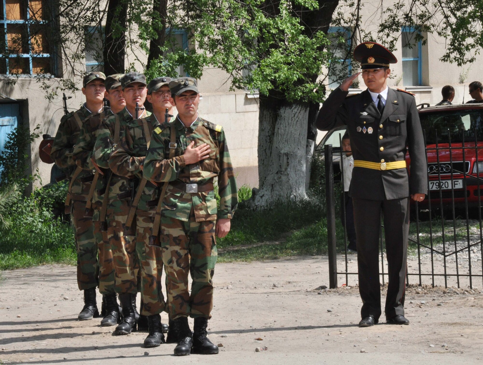 Kyrgyz military members salute the Kyrgyz Flag during a Victory Day ceremony in Manas Village May 9, 2010. The mayor invited Col. Blaine Holt and Chief Master Sgt. James Dowell, the director and command chief for the Transit Center at Manas, to participate in the event, which honored living veterans and members of Manas Village who gave their lives during the Great Patriotic War (WWII). (U.S. Air Force photo/Staff Sgt. Carolyn Viss)