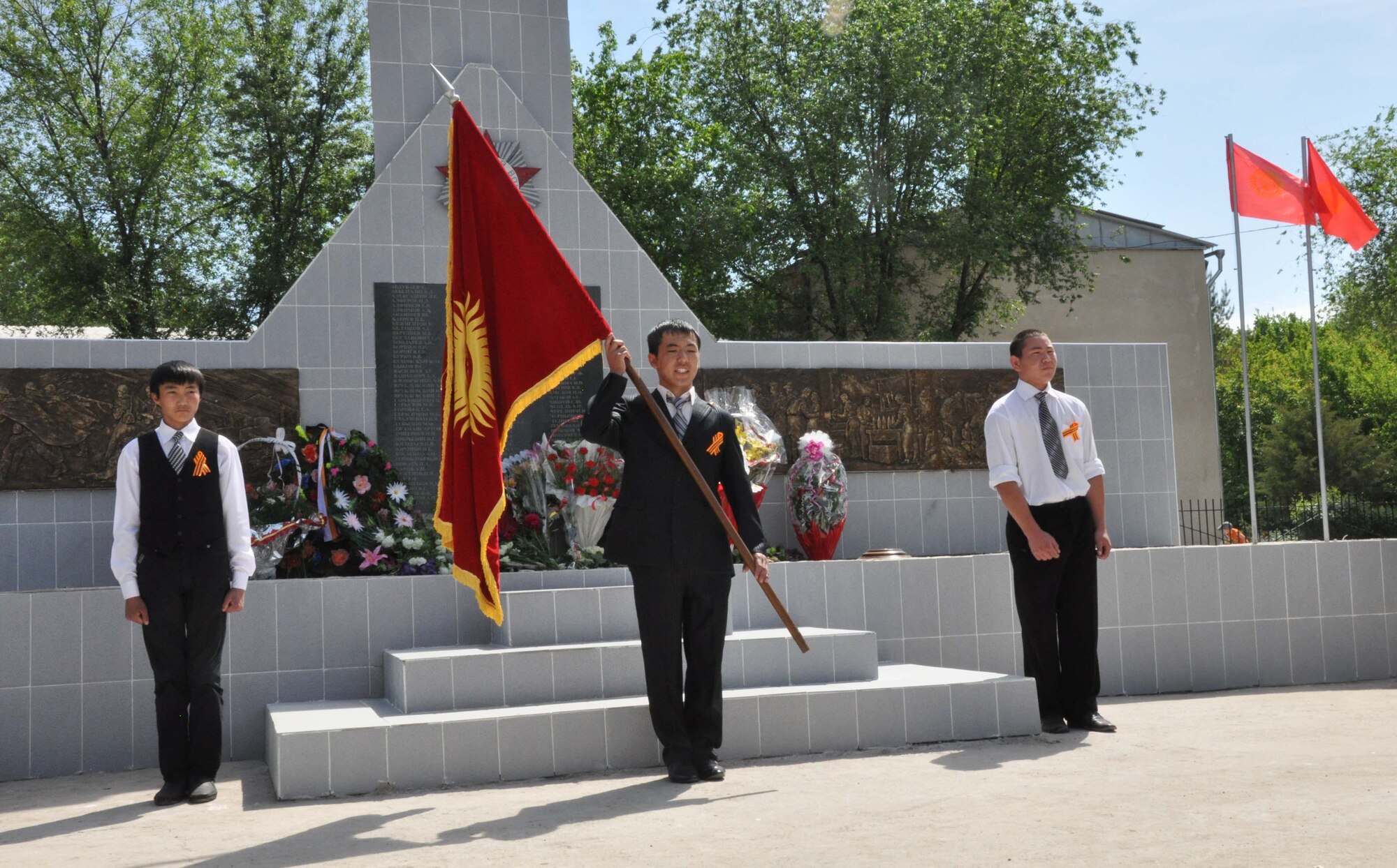 Three Kyrgyz young men perform closing ceremonies during a Victory Day ceremony in Manas Village May 9, 2010. The mayor invited Col. Blaine Holt and Chief Master Sgt. James Dowell, the director and command chief for the Transit Center at Manas, to participate in the event, which honored living veterans and members of Manas Village who gave their lives during the Great Patriotic War (WWII). (U.S. Air Force photo/Staff Sgt. Carolyn Viss)