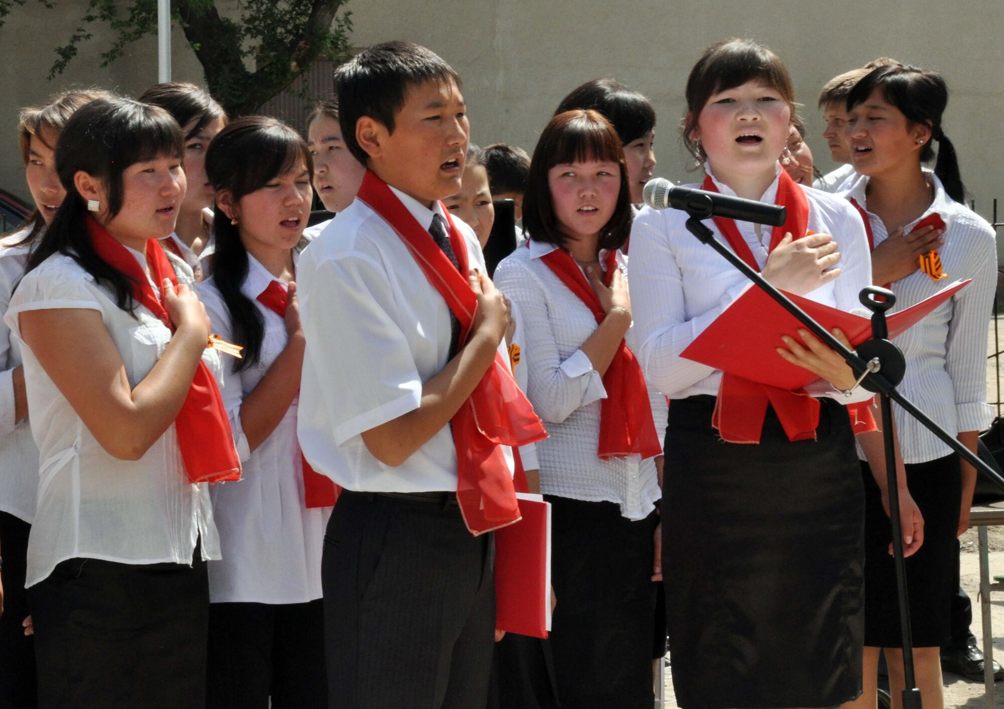 Kyrgyz children from Manas Village, Kyrgyzstan, sing the Kyrgyz national anthem during a Victory Day ceremony in Manas Village May 9, 2010. The mayor invited Col. Blaine Holt and Chief Master Sgt. James Dowell, the director and command chief for the Transit Center at Manas, to participate in the event, which honored living veterans and members of Manas Village who gave their lives during the Great Patriotic War (WWII). (U.S. Air Force photo/Staff Sgt. Carolyn Viss)