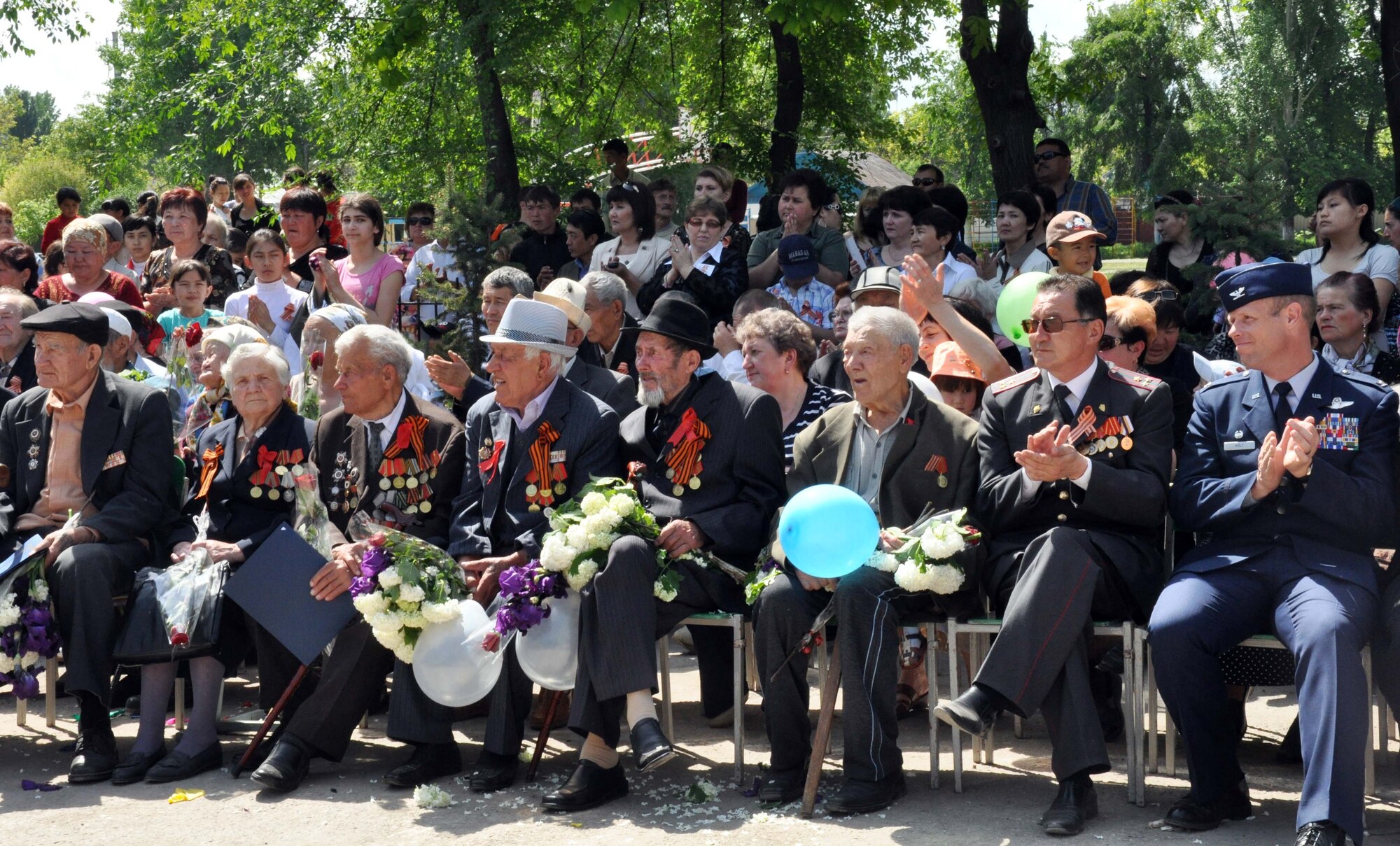 U.S. Air Force Col. Blaine Holt, the director of the Transit Center at Manas (right), celebrates Victory Day with the Mayor, Mr. Beshimbaev Kabylbek (second to right), in Manas Village, Kyrgyzstan, May 9, 2010. During the event, four living veterans of the Great Patriotic War (WWII), also pictured, were honored and a memorial wall was unveiled with about 50 names etched in stone of Manas patriots who died during the war. (U.S. Air Force photo/Staff Sgt. Carolyn Viss)
