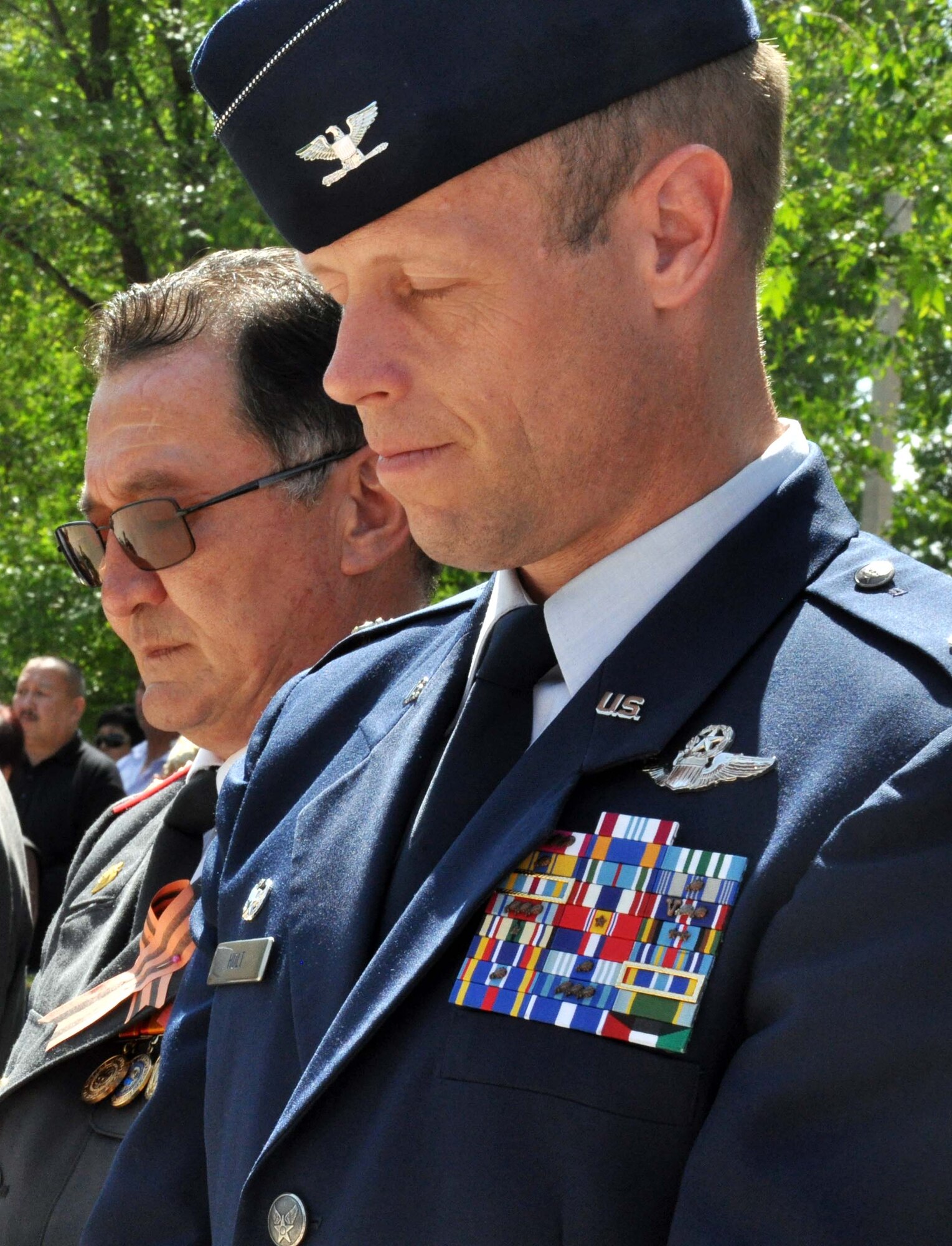 Mr. Beshimbaev Kabylbek, the mayor of Manas Village, Kyrgyzstan (left), and U.S. Air Force Col. Blaine Holt, the director of the Transit Center at Manas, observe a moment of silence for the members of Manas Village who gave their lives in service to their country in the Great Patriotic War (WWII) during a Victory Day ceremony in Manas May 9, 2010. During the event, a memorial wall was unveiled with about 50 names etched in stone of Manas patriots who died during the war. (U.S. Air Force photo/Staff Sgt. Carolyn Viss)