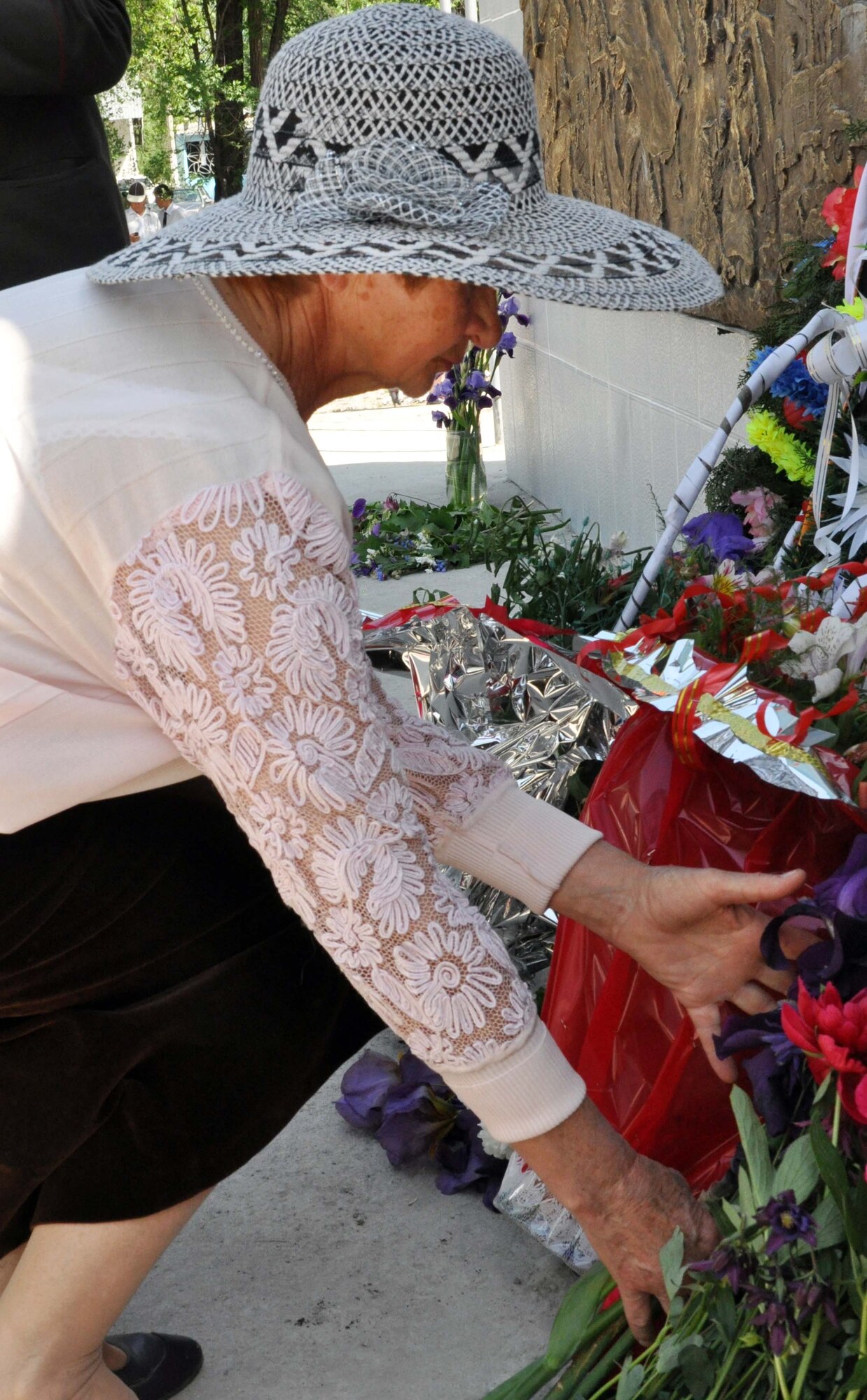 A Kyrgyz woman places flowers in front of a memorial wall, which was unveiled during a Victory Day ceremony in Manas Village, Kyrgyzstan, May 9, 2010. This day marked the end of the Great Patriotic War (WWII) and the end of the Nazi regime in 1945. During the event, this memorial wall was unveiled with about 50 names etched in stone of Manas patriots who died during the war, including this woman?s loved one. The mayor invited Col. Blaine Holt and Chief Master Sgt. James Dowell, the director and command chief for the Transit Center at Manas, to participate in the event. (U.S. Air Force photo/Staff Sgt. Carolyn Viss)