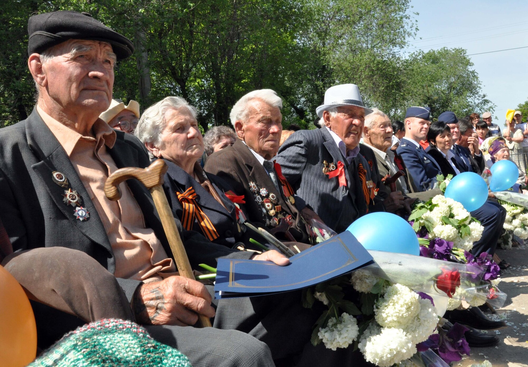 Veterans of the Great Patriotic War (WWII) watch the Victory Day ceremony in Manas Village, Kyrgyzstan, May 9, 2010. The mayor invited Col. Blaine Holt and Chief Master Sgt. James Dowell, the director and command chief for the Transit Center at Manas (right), to participate in the celebration, which marked the end of the Nazi regime. During the event, a memorial wall was unveiled, with about 50 names etched in stone of Manas patriots who died during the war. (U.S. Air Force photo/Staff Sgt. Carolyn Viss)