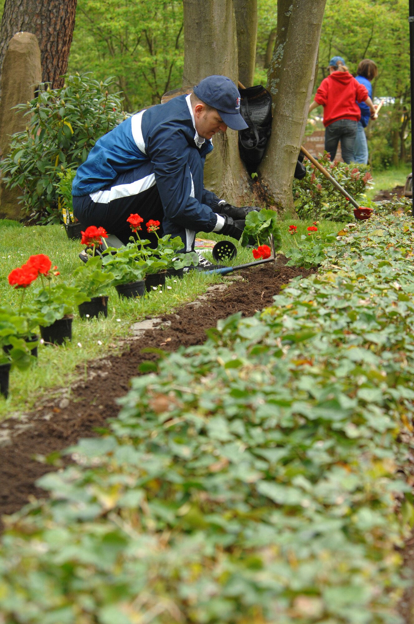 U.S. Air Force Senior Master Sgt. Randy Sadler, 603rd Air Operations Center, Air Mobility Division superintendent plants geraniums on the grounds of the Kaiserslautern Kindergraves Memorial Cemetery in preparation for a yearly remembrance ceremony.The 2010 Kindergraves memorial ceremony will take place May 15 at 10 a.m. at the U.S. Army Daenner Kaserne Chapel. (U.S. Air Force photo by Tech. Sgt. Michael Voss)