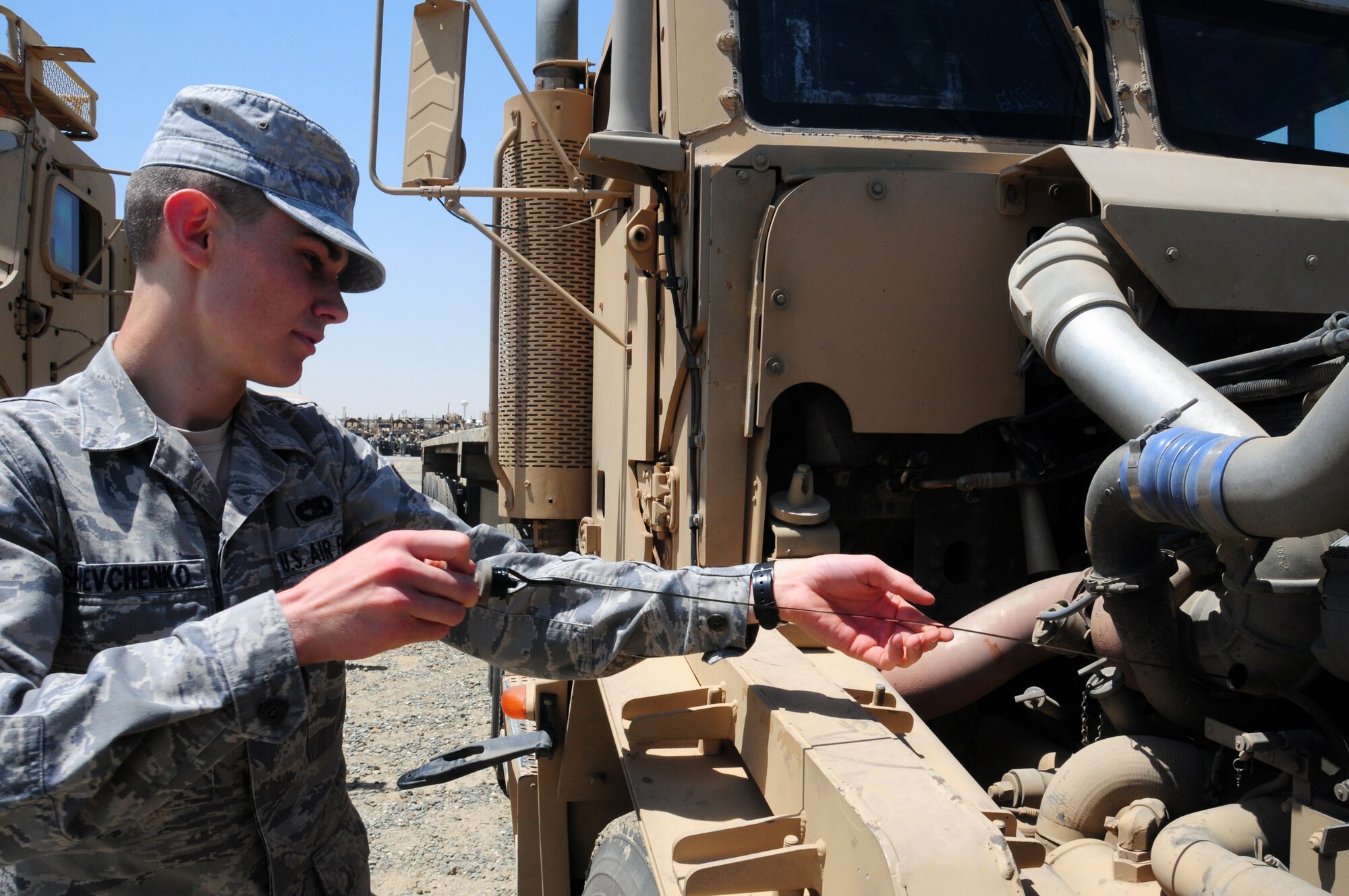 U.S. Air Force Airman 1st Class Anton Shevchenko, 586th Air Expeditionary Group truck and trailer operator, checks the fluid levels in his truck. Airman Shevchenko is a Lewisburg, Penn. native deployed from Moody Air Force Base, Ga. (U.S. Air Force photo by Staff Sgt. Lakisha A. Croley/Released)