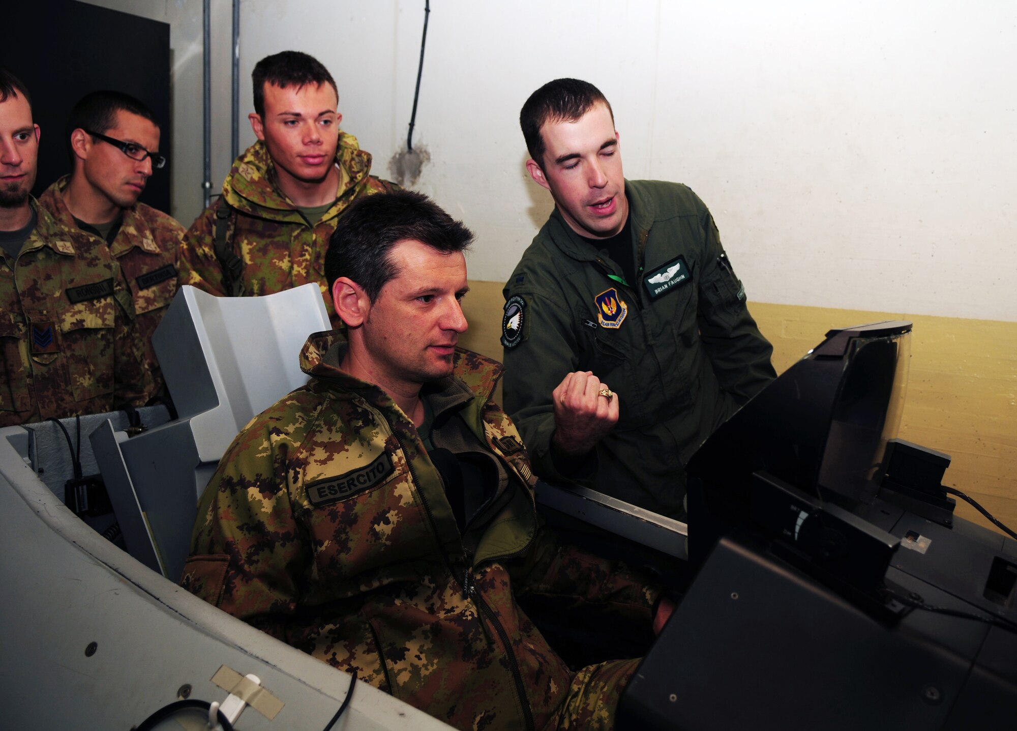 1st Lt. Brian Faughn, 555th Fighter Squadron F-16 Fighting Falcon pilot, teaches members of the G3 Southern Europe Task Force on how to use the F-16 flight simulator on May 5. All members of the G3 SETAF received an opportunity to use the flight simulator. (U.S. Air Force photo/ Staff Sgt. Taylor L. Marr)