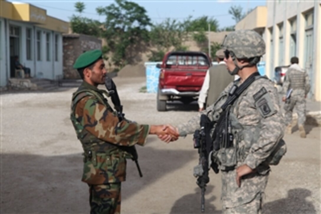 U.S. Army 1st Lt. Nicholas Eidemiller of 1st Platoon, Able Company, 2nd Battalion (Airborne), 503rd Infantry Regiment, 173 Airborne Brigade Combat Team shakes hands with a member of the Afghan National Army in the Noorgal district, Kunar province, Afghanistan, on May 1, 2010.  This was part of a community development council meeting.  
