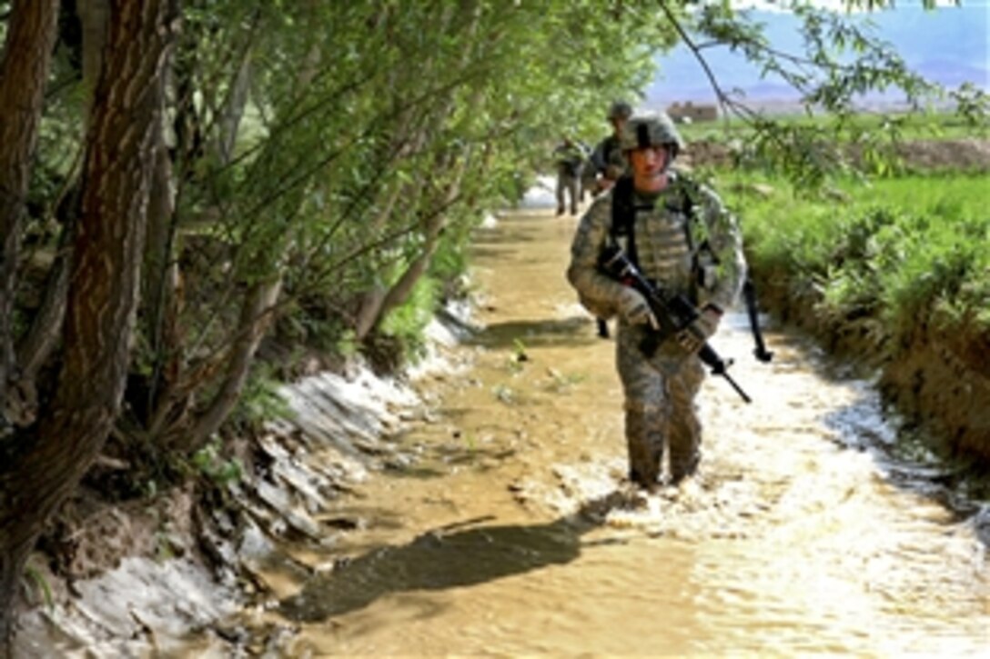 U.S. Army soldiers wade through a small creek while conducting a dismounted patrol in the village of Babus in Pole-Elam district, Afghanistan, May 7, 2010. The soldiers are assigned to the 264th Route Clearance Company, 27th Engineer Battalion, Task Force Tiger Engineer Brigade.