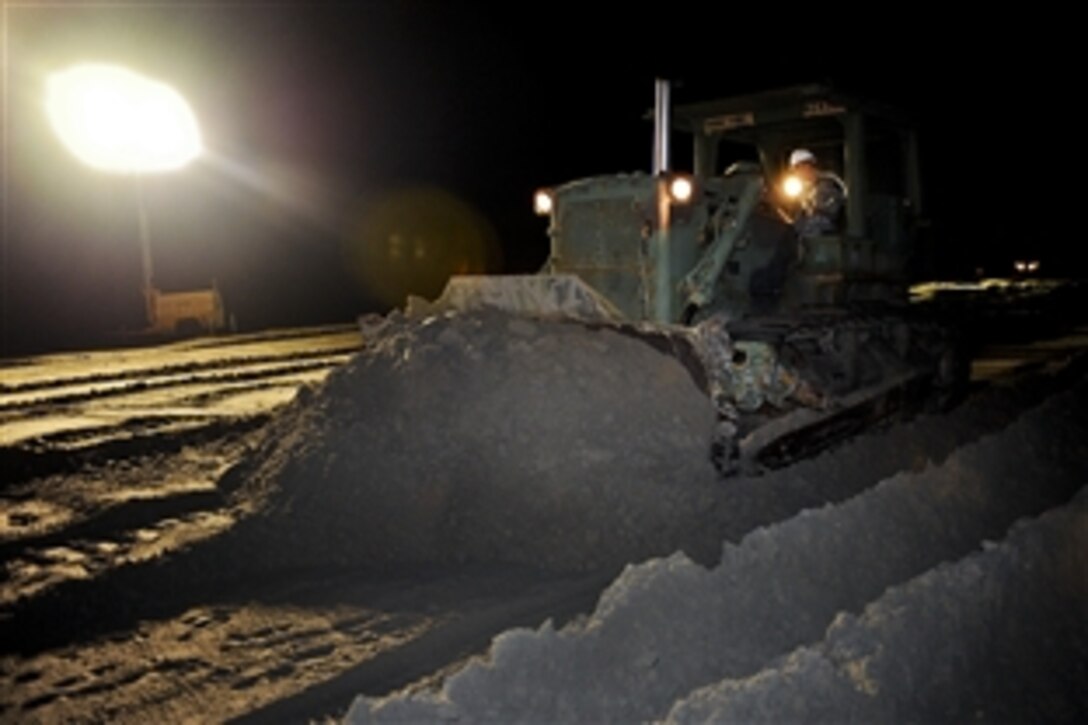 U.S. Army Spc. Collen Parent works through the night bulldozing sand to close a strait between two peninsulas near Grand Isle, La., May 9, 2010. The closure will be a secondary defense in addition to the boom line in the Gulf of Mexico to prevent oil from reaching further inland. Parent is a heavy equipment operator assigned to the Louisiana National Guard’s 922nd Horizontal Engineer Company, 769th Engineer Battalion.