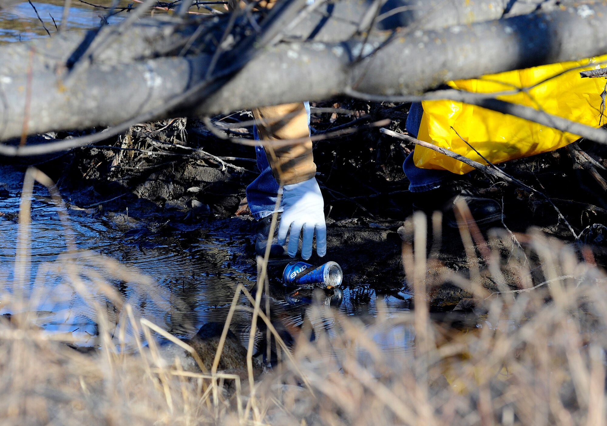 Tech. Sgt. Dennis Torres picks up a can on the bank of Ship Creek during the 26th Annual Creek Cleanup May 8. The event was sponsored by The Anchorage Alaska Waterways and The Municipality of Anchorage.  Sergeant Torres is assigned to the 525th Aircraft Maintenance Unit, Elmendorf Air Force Base, Alaska. (Air Force photo by Staff Sgt. Brian Ferguson)