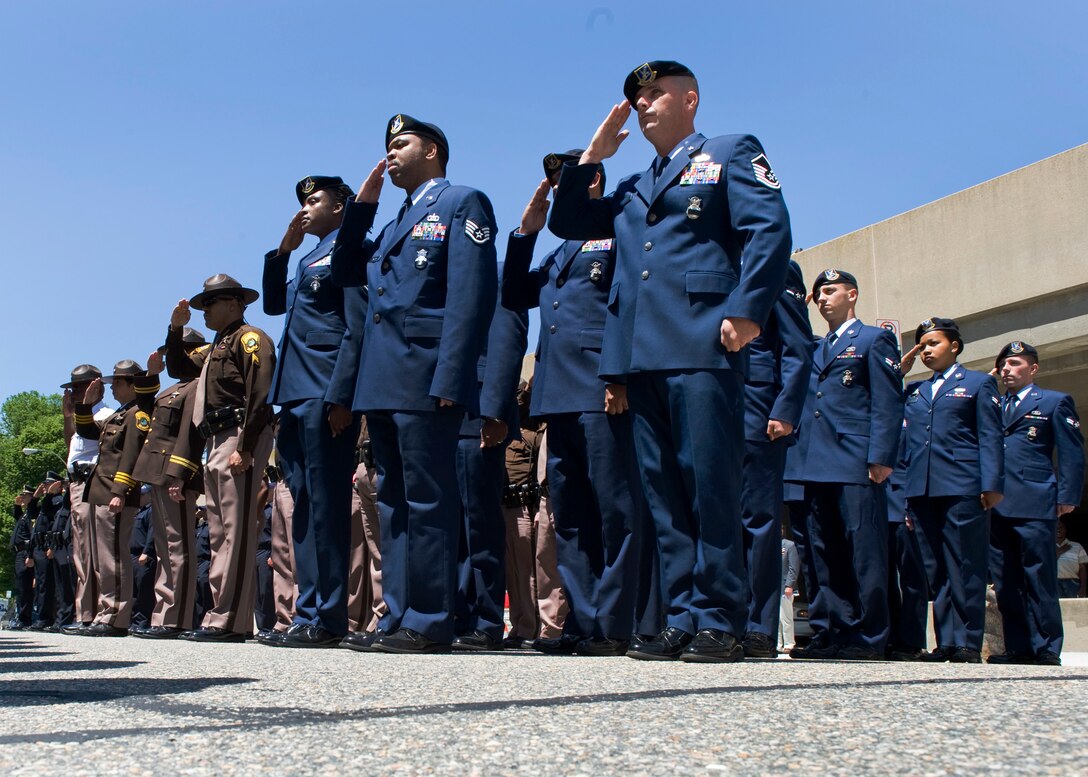 LANGLEY AIR FORCE BASE, Va. -- Members of 633d Air Base Wing Security Forces Squadron and local law enforcement pay tribute to the flag during the national anthem as part of the Newport News Police Department Memorial Service in downtown Newport News May 10.  This event is held as part of National Police Week, which began May 9 and will conclude May 15, honoring police officers, military and civilians, who have lost their lives in the line of duty. (U.S. Air Force photo/Senior Airman Zachary Wolf)