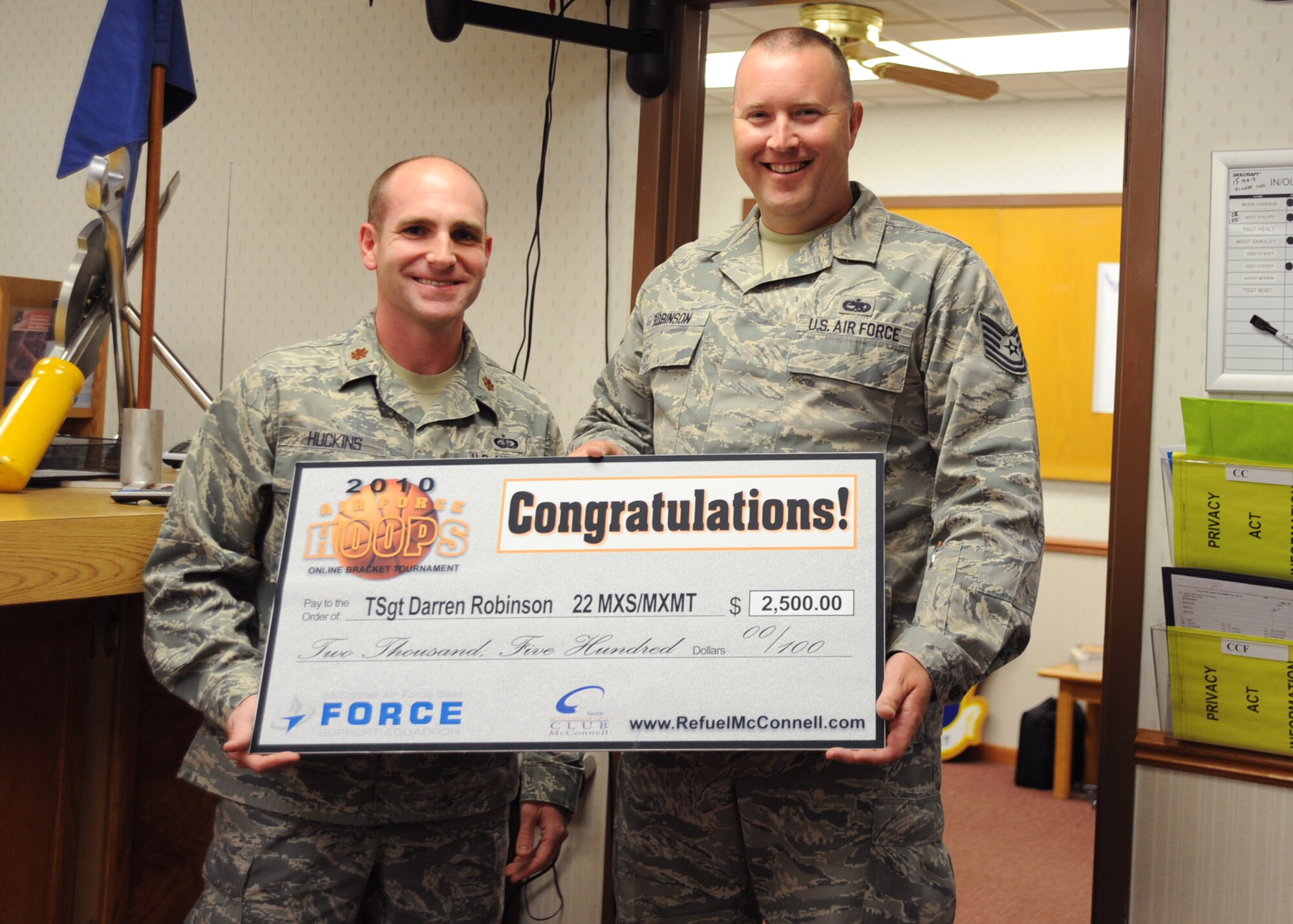 Maj. Colin Huckins, 22nd Force Support Squadron commander, presents a check to Tech Sgt. Darren Robinson, 22nd Maintenance Squadron isochronal dock controller, in the amount of $2,500 May 7, 2010, McConnell Air Force Base, Kan. Sergeant Robinson was the third place winner of the 2010 Air Force Hoops online bracket tournament for the men’s basketball National Collegiate Athletic Association. The bracket tournament was an Air Force Services March madness raffle. More than 14,000 Airmen participated in the raffle Air Force-wide. (U.S. Air Force photo/Senior Airman Maria Ruiz) 