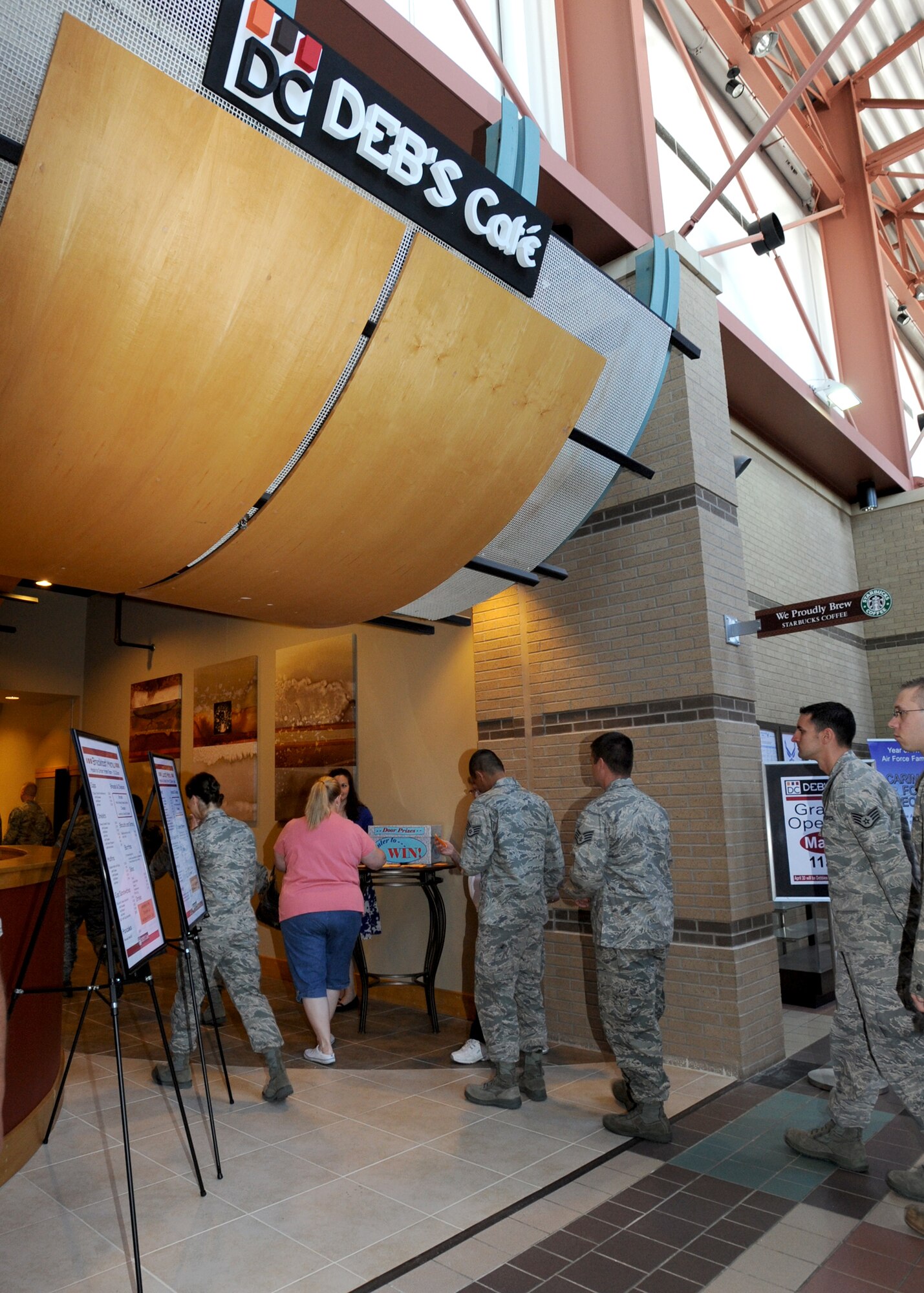 McConnell Airmen stand in line for the grand re-opening of Deb’s Café May 6, 2010, McConnell Air Force Base, Kan. Customers were given a chance to enter their names in a raffle for free coffee giveaways and coffee samples while waiting for their food. The new location will be able to serve more people with a variety of hot off the grill and pre-made meals. (U.S. Air Force photo/Airman 1st Class Andrea Salazar)