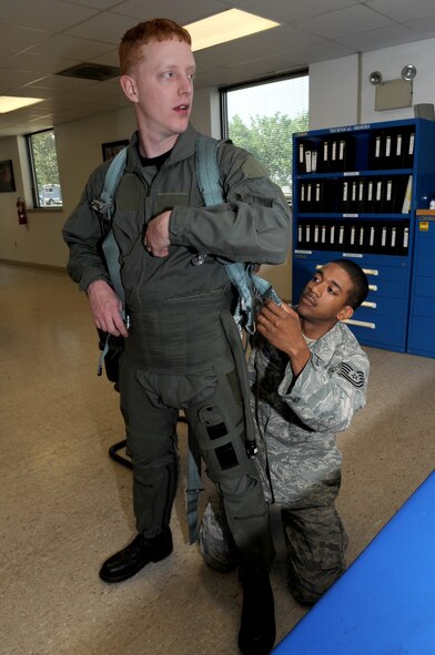 SEYMOUR JOHNSON AIR FORCE BASE, N.C. -- Tech. Sgt. Alvin Edmunds adjust Staff Sgt. Johnathan Bertini's parachute harness after fitting him in a anti-G suit during an aircrew flight equipment competition here, May 6, 2010. The harness, equipped with a 150-foot cord designed to help the aircrew members repel from trees, connects to a parachute. Sergeant Edmunds and Sergeant Bertini are both aircrew flight equipment technicians from the 4th Operations Support Squadron. Sergeant Edmunds is from Danville, Va. and Sergeant Bertini is from Buffalo, N.Y.  (U.S. Air Force photo/Staff Sgt. Courtney Richardson) 