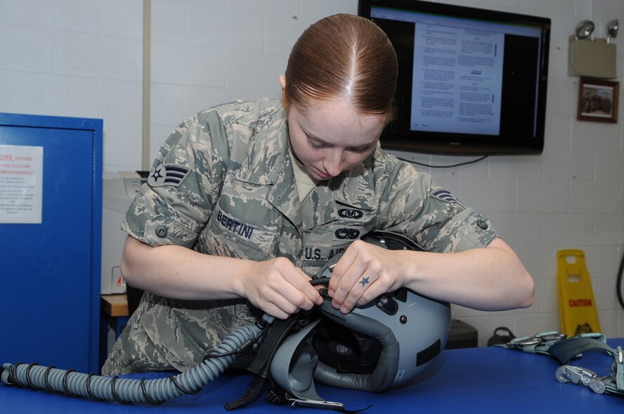 SEYMOUR JOHNSON AIR FORCE BASE, N.C. -- Senior Airman Emily Bertini removes a mask from a flight helmet during an aircrew flight equipment competition here, May 6, 2010. After testing and fitting a mask to an aircrew member, Airman Bertini secures all the loose straps with A8 wax string. Airman Bertini, 4th Operations Support Squadron aircrew flight equipment technician, hails from Springtown, Texas. (U.S. Air Force photo/ Staff Sgt. Courtney Richardson)