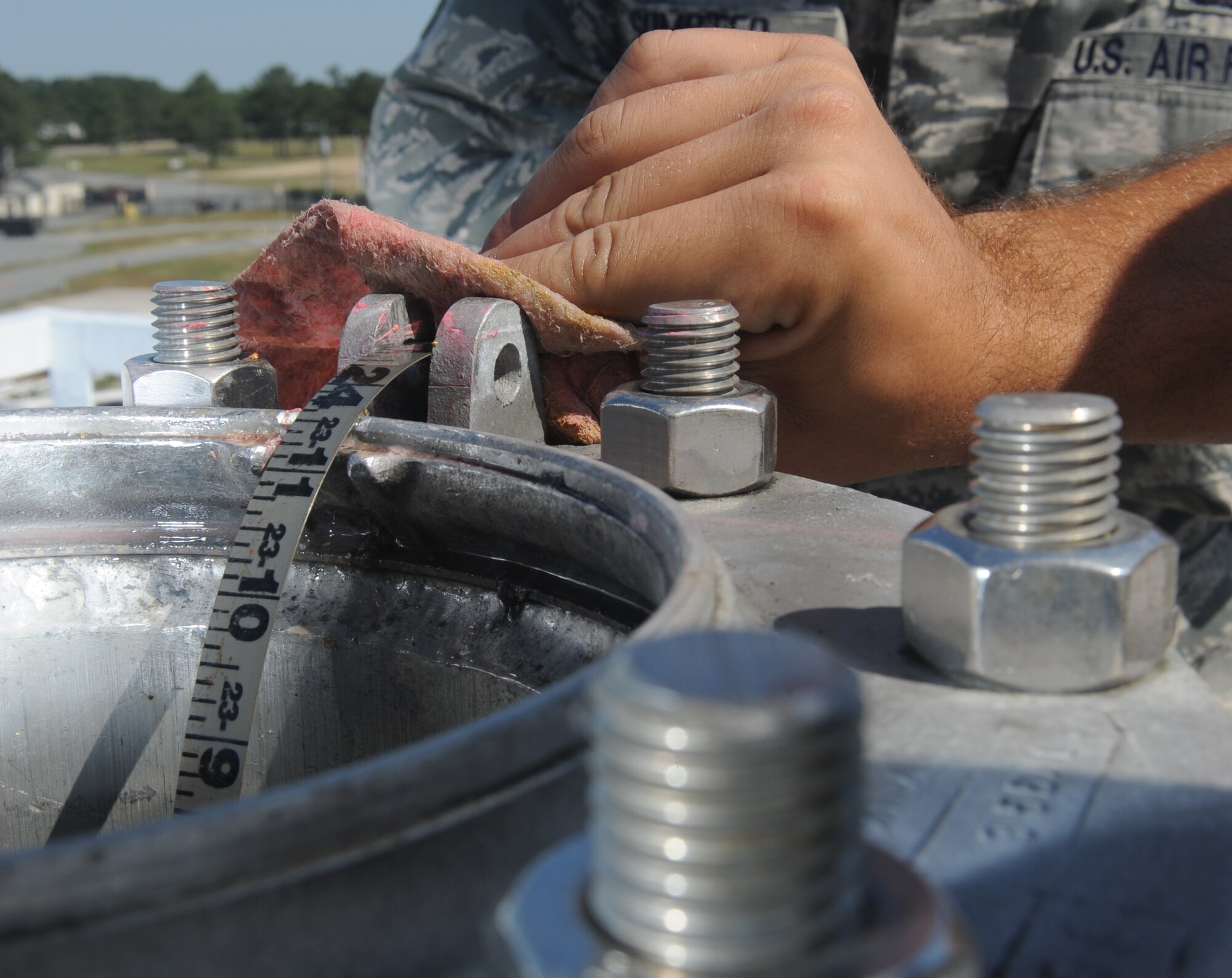 SEYMOUR JOHNSON AIR FORCE BASE, N.C. – Senior Airman Matthew Jones wipes fuel off a tape and bob as Staff Sgt. Shawn Sumpter reels in the bob during the 4th Logistics Readiness Squadron fuels turkey shoot competition here May 7, 2010. The competition consisted of a knowledge test and timed events to include maneuvering an R-11 refueling truck through an obstacle course, climbing a fuel tank and manually checking the fuel level, and conducting a fuels system icing inhibitor test in the lab. Airman Jones, a 4th LRS fuels distribution operator, hails from West Deer, Pa. Sergeant Sumpter, a 4th LRS fuels distribution supervisor, is a native of Oak Hill, W.V. (U.S. Air Force photo/Staff Sgt. Heather Stanton)