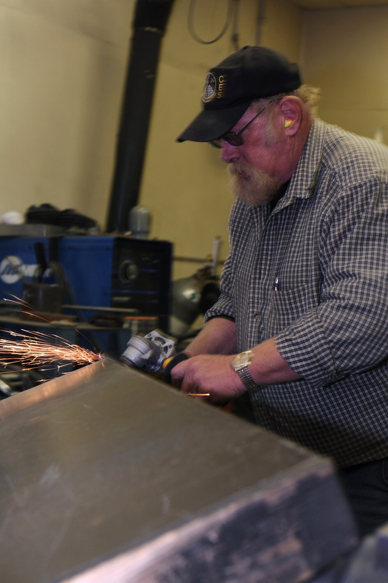 MINOT AIR FORCE BASE, N.D. -- Barry Grindberg, 5th Civil Engineer Squadron electrical journeyman, smoothes out the edge of a shooting door here May 6.  The structures shop reshaped 20 doors to help with the remodeling of the base combat arms firing range. (U.S. Air Force photo by Tech. Sgt. Lee A. Osberry Jr.)