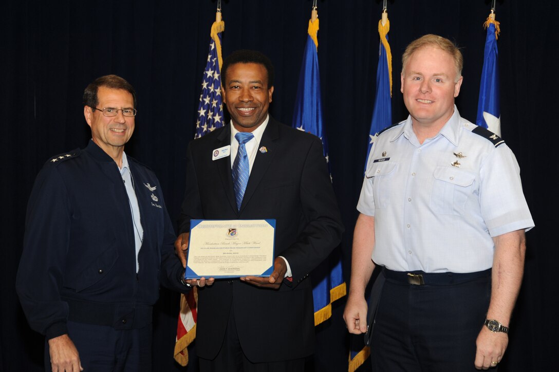 Lt. Gen. John "Tom" Sheridan (left), Space and Missile Systems Center commander, presents an Honorary Commander certificate to Mr. Mitch Ward (center), City of Manhattan Beach mayor, while Col. Roger Teague, Space Based Infrared Systems Wing commander, looks on at an induction ceremony April 26 in the Gordon Conference Center. Hermosa Beach, SCNG's counterpart, is part of the Los Angeles Air Force Base Support Team whose purpose is to identify common areas of interest between the civilian and military communities, assist in promoting community understanding, support the Los Angeles AFB mission and host social events and sponsor entertainment that enhance the morale, camaraderie and espirit de corps of Los Angeles AFB personnel and their families. (Photo by Joe Juarez)