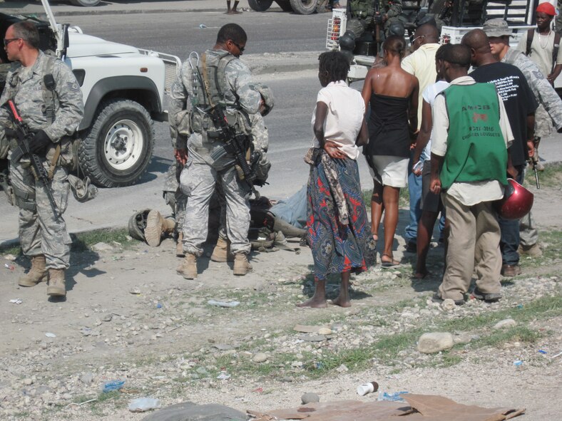 PORT-AU-PRINCE, Haiti -- Members of the 823rd Expeditionary Security Forces Squadron crowd around an injured pedestrian here May 7. Thanks to the quick response of Senior Airmen Alexander Parrilla, 823rd ESFS entry controller, the squadron was able to quickly respond and help save the woman’s life. (Contributed photo/RELEASED)