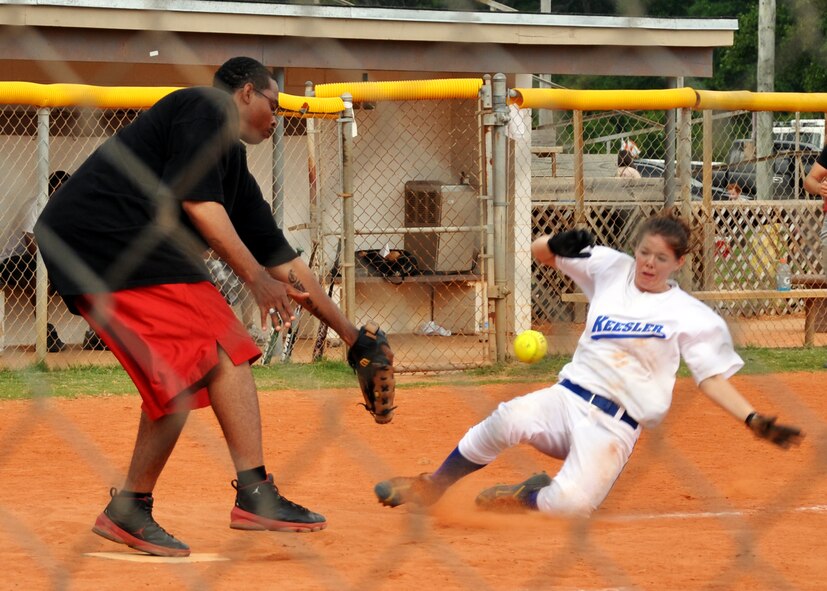 A Keesler AFB player slides into home as the Tyndall AFB catcher tries to make the play during the 2010 Police Week softball tournament held at Eglin Air Force Base, Fla., May 8.  96th Security Forces Squadron won the tournament with a perfect record.  Proceeds raised by the tournament will go to a police officers' memorial.  (U.S. Air Force photo/Ashley M. Wright.)