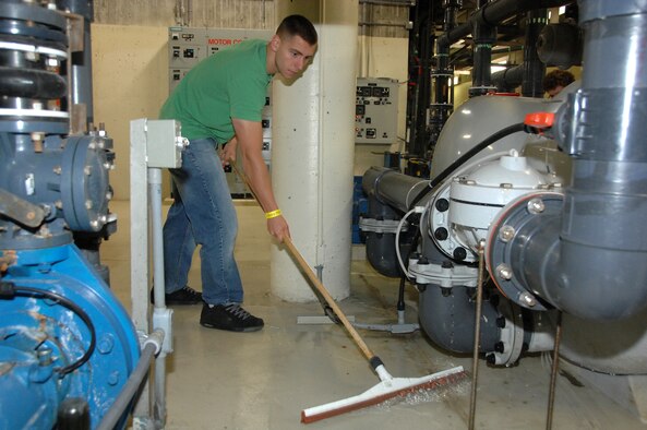 OFFUTT AIR FORCE BASE, Neb. -- Staff Sgt. Kyle Gundrum, 343rd Reconnaissance Squadron, pushes water into a drain while cleaning a sand filtering system that supports the Open Ocean exhibit of the Scott Aquarium at the Henry Doorly Zoo in Omaha, Neb., during the zoo's annual clean up day May 8. Sergeant Gundrum joined several volunteers from Offutt to help clean the zoo. U.S. Air Force photo by Delanie Stafford
