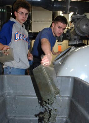OFFUTT AIR FORCE BASE, Neb. -- Kyle Ginnaty (left) and his brother Ian (right), both sons of Maj. Matthew Ginnaty, U.S. Strategic Command, remove sand from the sand filtering system, which cleans the water inside the Open Ocean exhibit of the Scott Aquarium at the Henry Doorly Zoo in Omaha, Neb., during the zoo's annual clean up day 8. The duo joined several volunteers from Offutt to clean the zoo. U.S. Air Force photo by Delanie Stafford
