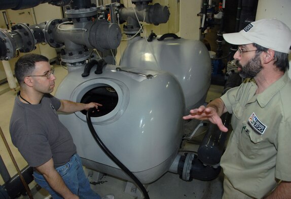 OFFUTT AIR FORCE BASE, Neb. -- Maj. Matthew Ginnaty (left), U.S. Strategic Command, siphons water from the sand filtering system that cleans the water inside the Open Ocean exhibit of the Scott Aquarium, while Troy Solberg, the keeper of the aquarium, explains how the system works at the Henry Doorly Zoo in Omaha, Neb., during the zoo's annual clean up day May 8. Major Ginnaty joined several volunteers from Offutt to help clean the zoo. U.S. Air Force photo by Delanie Stafford