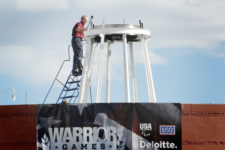 Former Dallas Cowboys quarterback Roger Staubach lights the ceremonial torch at the inaugural Warrior Games May 10, 2010, at the Olympic Training Center in Colorado Springs, Colo. Mr. Staubach is a U.S. Naval Academy graduate and Vietnam veteran. Athletes from each of the services will compete in archery, cycling, basketball, shooting, swimming, track and field and volleyball during the week-long games. (Defense Department photo/Fred W. Baker III)
