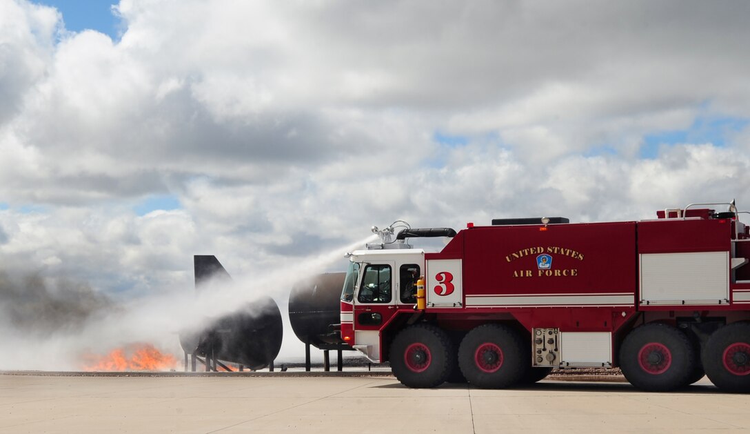 ELLSWORTH AIR FORCE BASE, S.D. -- Ellsworth firefighters put out a controlled fire during a demonstration for spouse day, May 7.  Spouses of the 28th Civil Engineer Squadron got a chance to ride in fire trucks, learn about hazardous material disposal and view an explosive ordnance disposal team destroy a simulated unexploded munition. (U.S. Air Force/photo Air man 1st Class Anthony Sanchelli)
