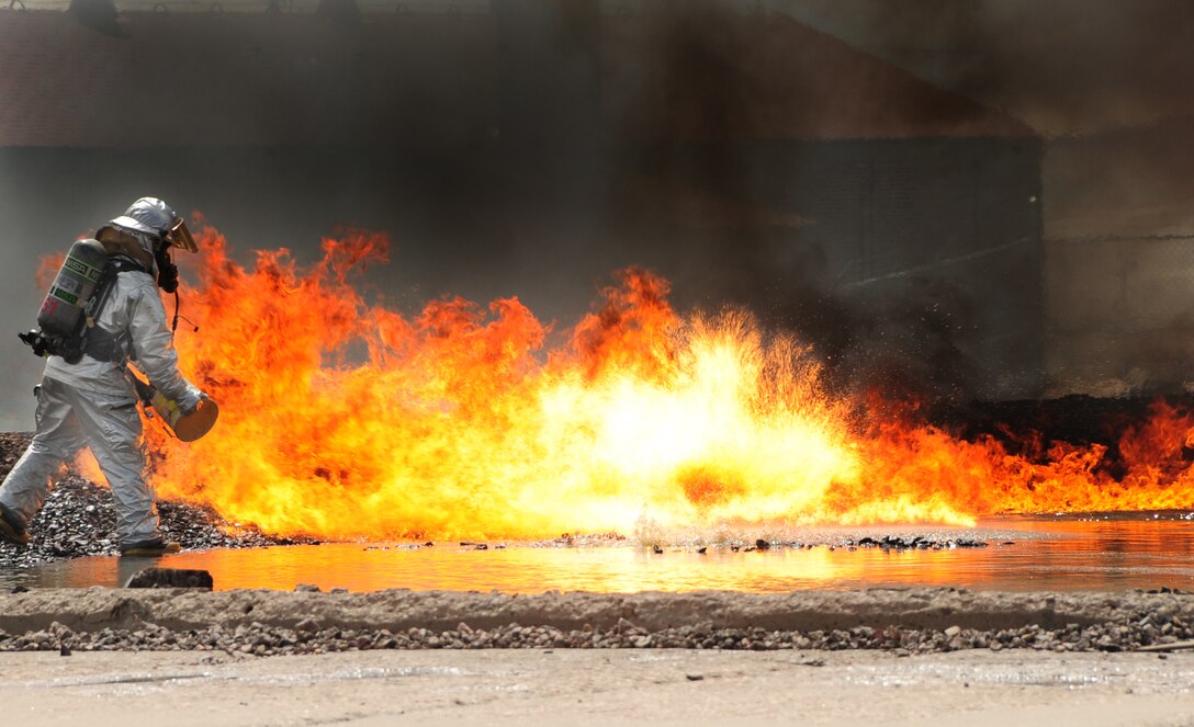 ELLSWORTH AIR FORCE BASE, S.D. -- Airman 1st Class Samantha Tremblay, 28th Civil Engineer Squadron firefighter, douses a controlled fire with fuel during a demonstration for spouse day, May 7.  Spouse day gave allowed military spouses to see firsthand what their loved ones do for the Air Force. (U.S. Air Force/photo Air man 1st Class Anthony Sanchelli)
