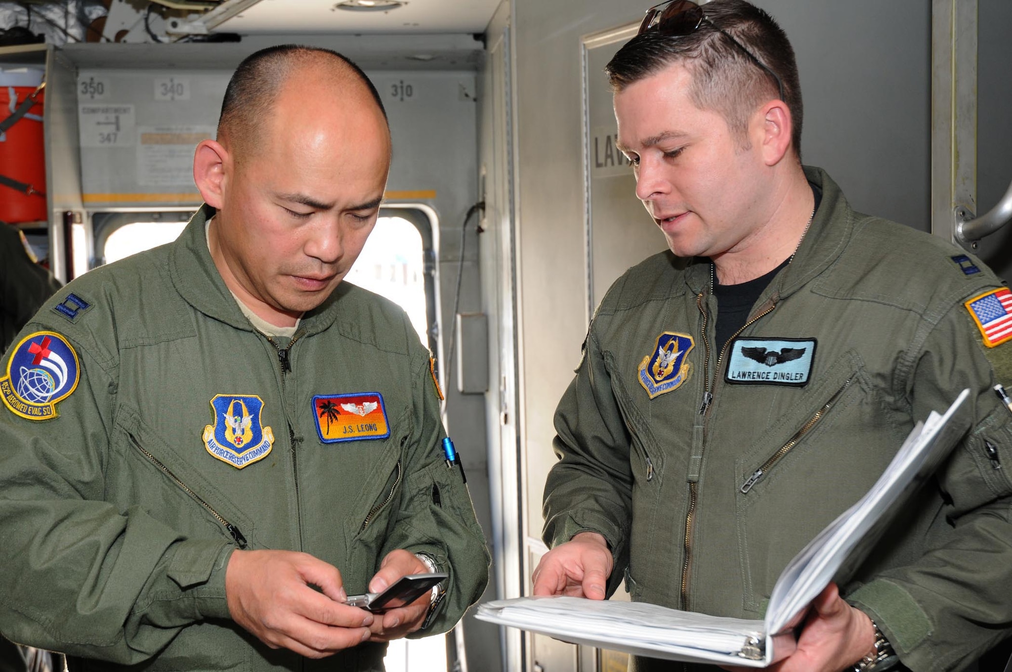 Capt. J.S. Leong of the 452nd Aeromedical Evacuation Squadron, March Air Reserve Base, Calif., and Capt. Lawrence Dingler, 326th Airlift Squadron pilot, coordinate the training schedule during an aeromedical evacuation exercise May 7-9.The 326th Airlift Squadron provided the airlift for the medical team, allowing them to train in a real-world environment. (U.S. Air Force photo/Senior Airman Andria J. Allmond) 