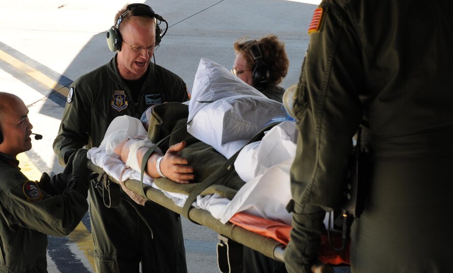 Tech. Sgt. Mick Callahan, 326th Airlift Squadron loadmaster (center), helps members of the 452nd Aeromedical Evacuation Squadron, March Air Reserve Base, Calif., unload a "patient" off a C-17 Globemaster III during an aeromedical evacuation exercise May 7-9. The 326th Airlift Squadron provided the airlift for the medical team, allowing them to train in a real-world environment. (U.S. Air Force photo/Senior Airman Andria J. Allmond) 