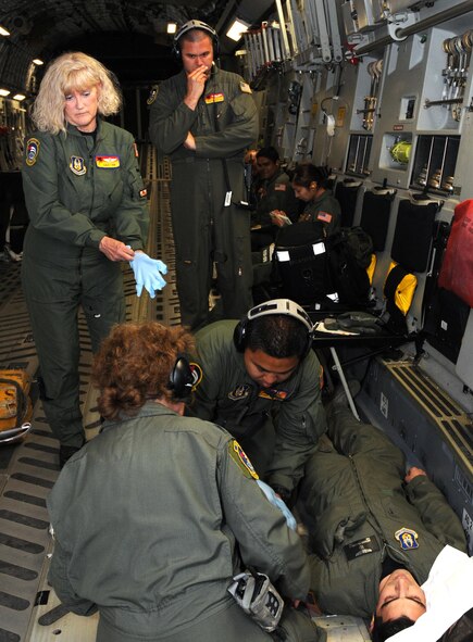 Members of the 452nd Aeromedical Evacuation Squadron, March Air Reserve Base, Calif., respond to a mock seizure of a 452nd AES Airman in the cargo area of a C-17 Globemaster III during an aeromedical evacuation exercise May 7-9. The 326th Airlift Squadron provided the airlift for the medical team, allowing them to train in a real-world enviornment. (U.S. Air Force photo/Senior Airman Andria J. Allmond) 
