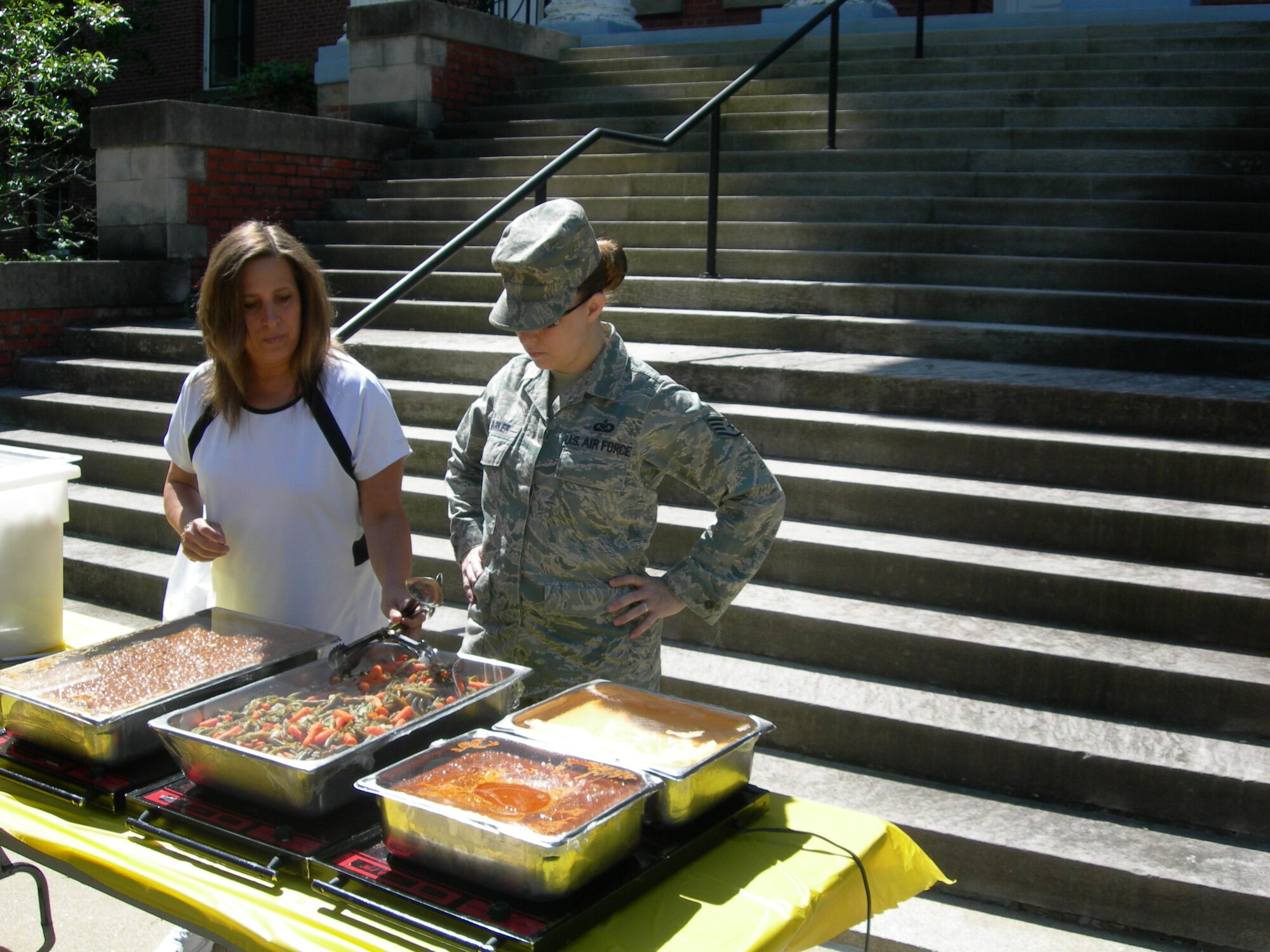 Staff Sgt. Stacey Barker, Air Force District of Washington, NCOIC Command and Control assists Ms. Carol Mitchell, Armed Forces Retirement Home, Recreation Therapist in preparation for the May Cookout for residents at the Armed Forces Retirement Home Washington, D.C., held on May 7, 2010. (U.S. photo by Aletha Frost)