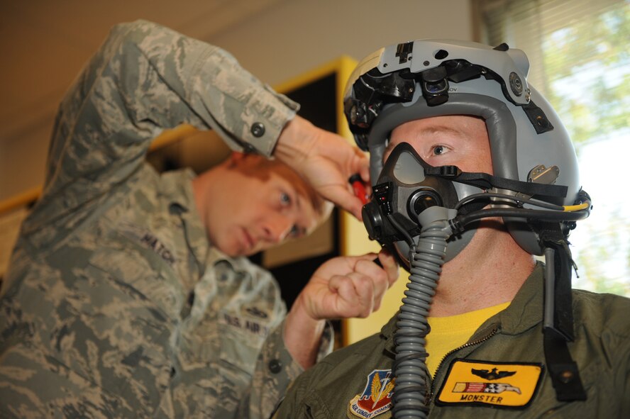 SEYMOUR JOHNSON AIR FORCE BASE, N.C. -- Staff Sgt. Cliff Hatch tightens screws on a joint helmet-mounted cueing system for Lt. Col. David Berg May 7, 2010. Sergeant Hatch is fitting Colonel Berg for his new JHMCS, which has a magnetic helmet-mounted tracker that determines where the pilot's head is pointed, combined with a miniature display system that projects information onto the pilot's visor. Sergeant Hatch, 336th Fighter Squadron aircrew flight equipment craftsman, hails from Richmond, Va. Colonel Berg, 336th Fighter Squadron commander, hails from Richland, Wash. (U.S. Air Force photo/Senior Airman Ciara Wymbs) 
