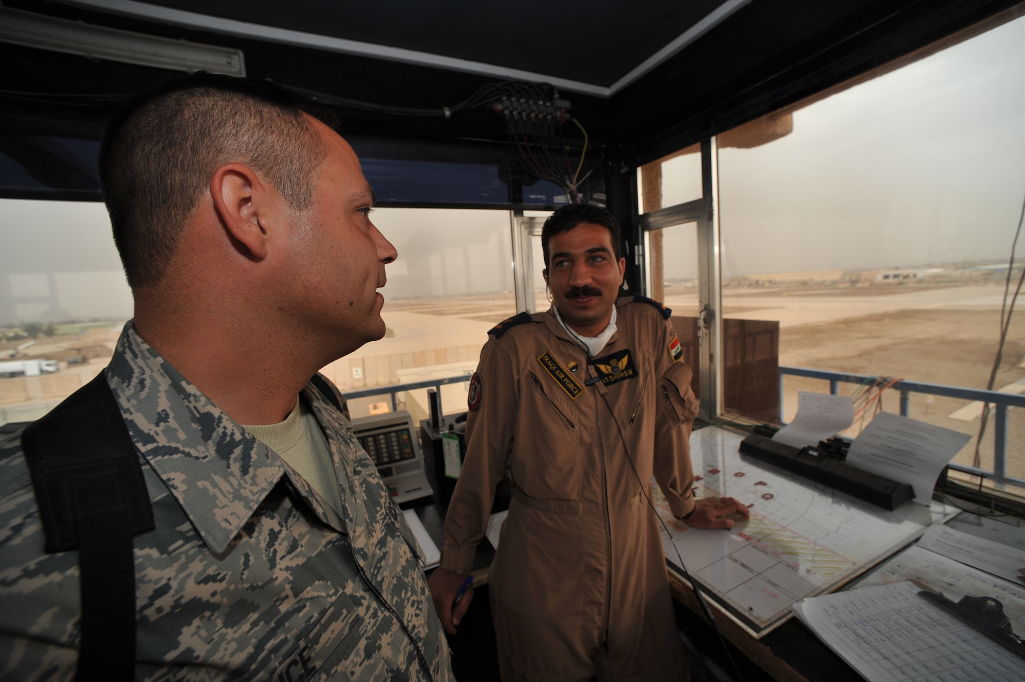 U.S. Air Force Staff Sgt. Shannon Grice talks with an Iraqi Air Force 2nd Lt. about air traffic controlling at Camp Taji, Iraq, April 17, 2010.  The Iraqi Trainig and Advisory Mission is in the process of transferring all operations to the Iraqi military for the U.S. draw down.  Sgt. Grice is assigned to the 347th Operational Support Squadron (OSS), Yokota AB, Japan.  (U.S. Air Force photo/Staff Sgt Quinton Russ/released)