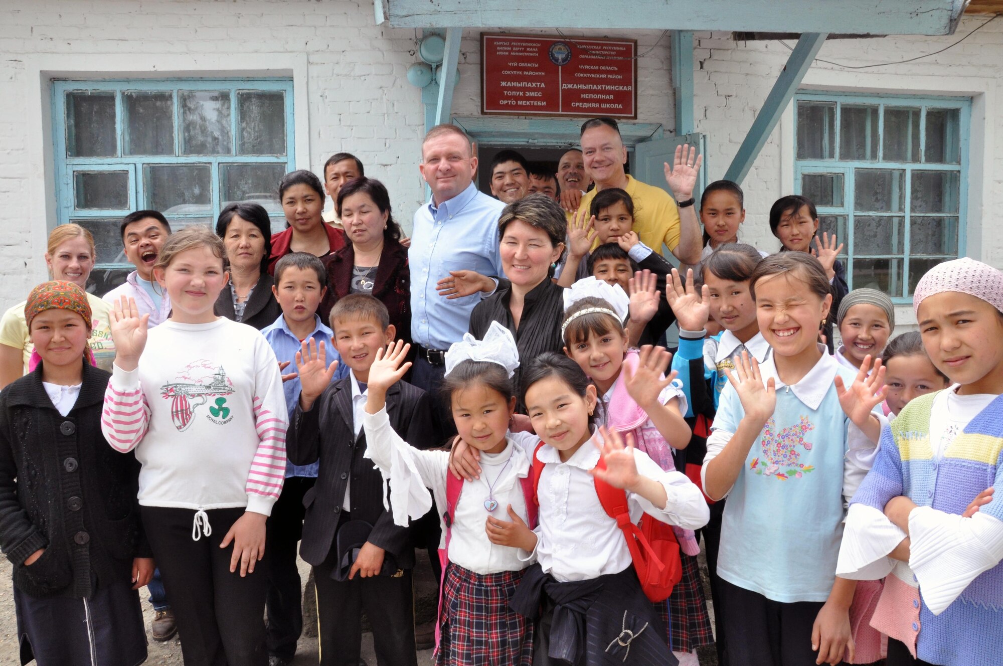 Airmen from the Transit Center at Manas, Kyrgyzstan, pose for a group photo with students of the Jany-Pakhta School during a humanitarian assistance visit May 11, 2010. Jany-Pakhta Schools are sponsored by Manas Area Benefit Outreach Society, and Airmen from the Transit Center visit regularly to play with children and give them textbooks and other items the schools need. (U.S. Air Force photo/Staff Sgt. Carolyn Viss)