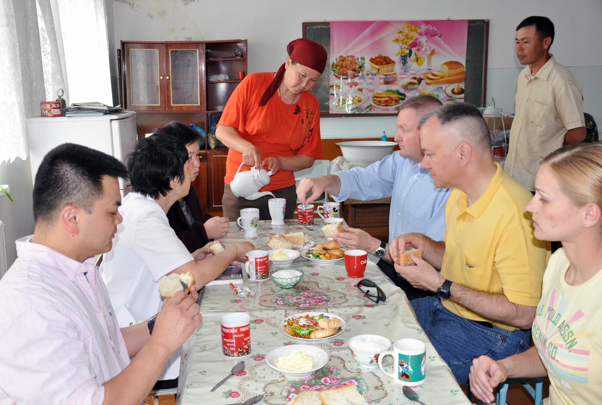 Airmen from the Transit Center at Manas, Kyrgyzstan, enjoy tea and snacks with staff members of the Jany-Pakhta School during a humanitarian assistance visit May 11, 2010. Jany-Pakhta Schools are sponsored by Manas Area Benefit Outreach Society, and Airmen from the Transit Center visit regularly to play with children and give them textbooks and other items the schools need. (U.S. Air Force photo/Staff Sgt. Carolyn Viss)
