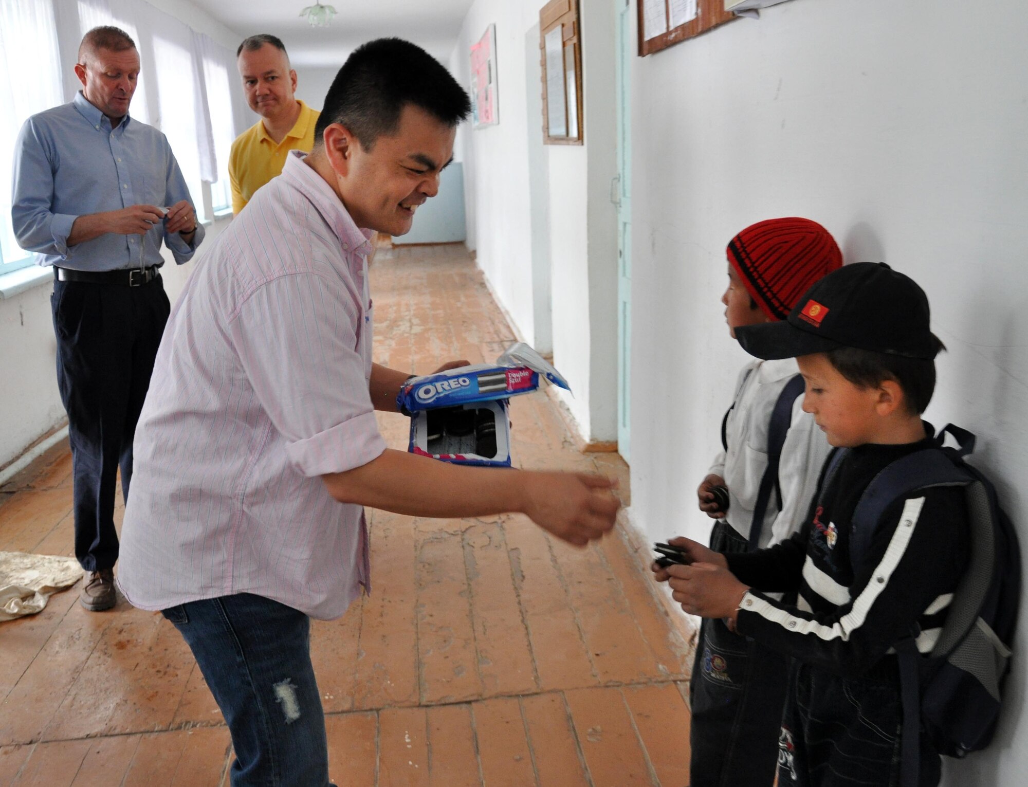Capt. Tom Mulka, the Manas Area Benefit Outreach Society president, gives cookies to children at the Jany-Pakhta School during a humanitarian assistance visit May 11, 2010. Jany-Pakhta Schools are sponsored by Manas Area Benefit Outreach Society, and Airmen from the Transit Center at Manas, Kyrgyzstan, visit regularly to play with children and give them textbooks and other items the schools need. (U.S. Air Force photo/Staff Sgt. Carolyn Viss)
