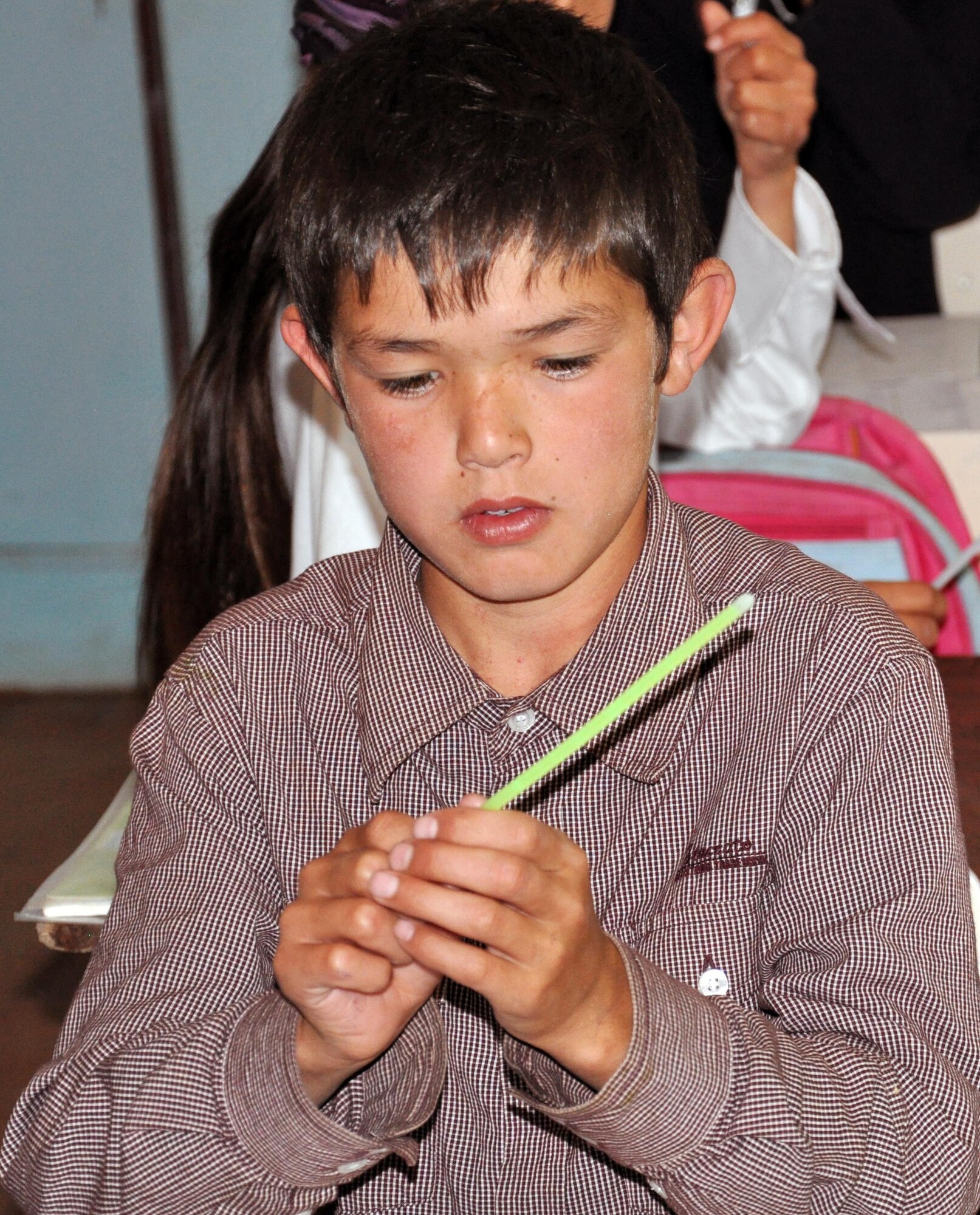 A Kyrgyz boy from the Jany-Pakhta School figures out how a glow stick works during a humanitarian assistance visit from Airmen from the Transit Center at Manas, Kyrgyzstan, May 11, 2010. (U.S. Air Force photo/Staff Sgt. Carolyn Viss)