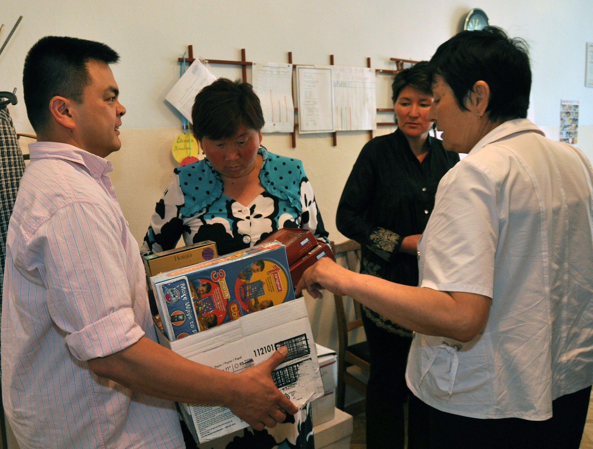 Capt. Tom Mulka, the Manas Area Benefit Outreach Society president, gives toys and games to staff of the Jany-Pakhta Elementary School, Kyrgyzstan, during a humanitarian assistance visit May 11, 2010. Jany-Pakhta Schools are sponsored by Manas Area Benefit Outreach Society, and Airmen from the Transit Center at Manas visit regularly to play with children and give them textbooks and other items the schools need. (U.S. Air Force photo/Staff Sgt. Carolyn Viss)