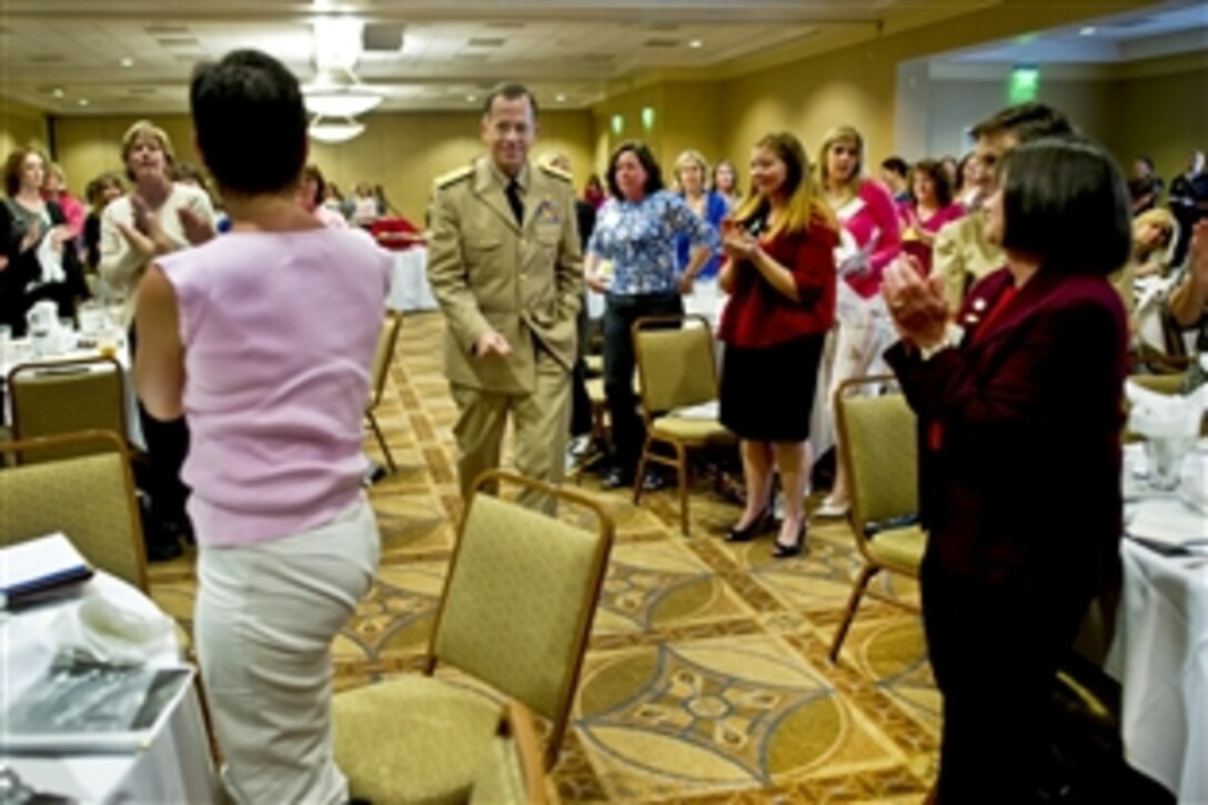 Navy Adm. Mike Mullen, chairman of the Joint Chiefs of Staff, arrives to a standing applause at the quarterly Continuum Of Resource Education spouses meeting at Naval Station Norfolk, Va., May 9, 2010. Mullen and his wife, Deborah, addressed attendees at the the Norfolk Fleet and Family Support Center, which hosts the quarterly meeting to aide spouses in leadership positions and the challenges they face filling these demanding positions.