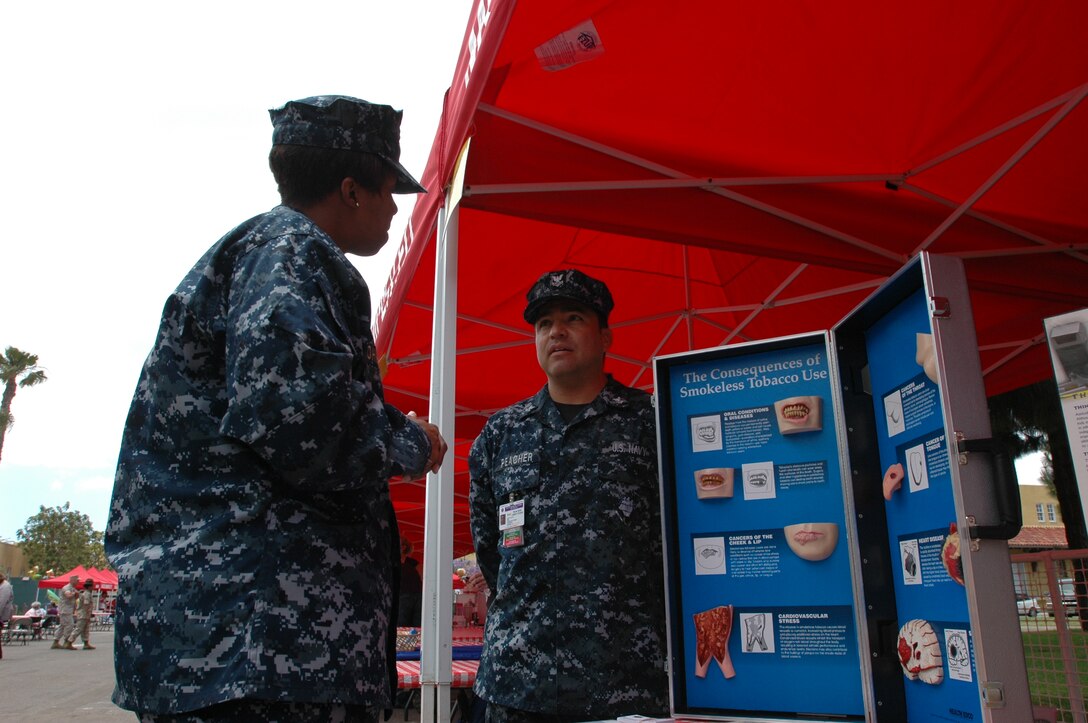 Petty officer second class Christopher Peacher, tobacco program manager, Naval Medical Center, San Diego and Lt. Cmdr. Patricia Johnson, branch medical senior nurse officer, Branch Medical Clinic, Marine Corps Recruit Depot San Diego, discuss the consequences of smokeless tobacco use, Tuesday May 11, at the Fitness and Wellness Expo.