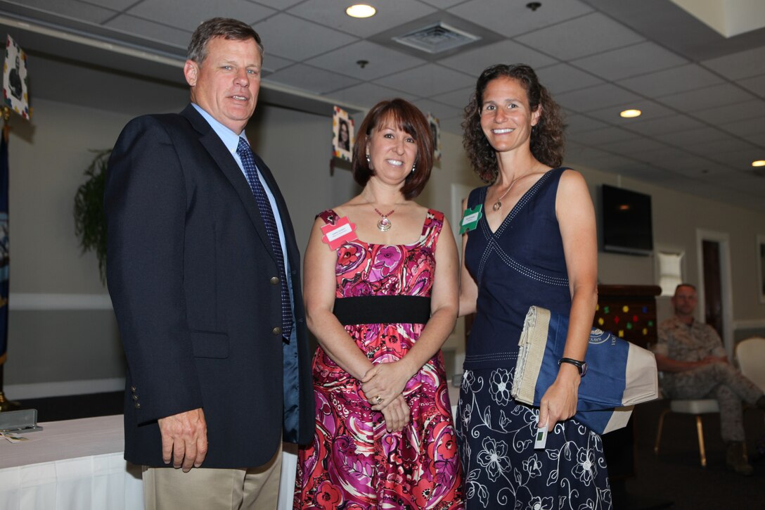 Ruth McDonough (right), a volunteer with Navy-Marine Corps Relief Society and wife of Lt. Col. John McDonough, commanding officer of 2nd Battalion, 2nd Marine Regiment, 2nd Marine Division, who is currently deployed to Helmand province, Afghanistan, poses with retired Col. William “Bill” Meier (left), executive officer of Marine Corps Base Camp Lejeune, and Leanne Couillard, the chairwoman of NMCRS volunteers, after receiving her volunteer award during the NMCRS Volunteer Awards and Recognition Ceremony aboard the base, May 12.  McDonough is one of 41 NMCRS volunteers who provide financial, educational, medical and other assistance to Marines and sailors in a time of need.