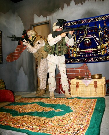 Sergeants Garrett Ferris (left) and Paul Peacock, both Infantry Officers Course instructors at The Basic School on Marine Corps Base Quantico, Va., test their gear in the Gruntworks’ Immersive Trainer. Peacock is wearing gear from 2001 while Ferris is in current gear.
