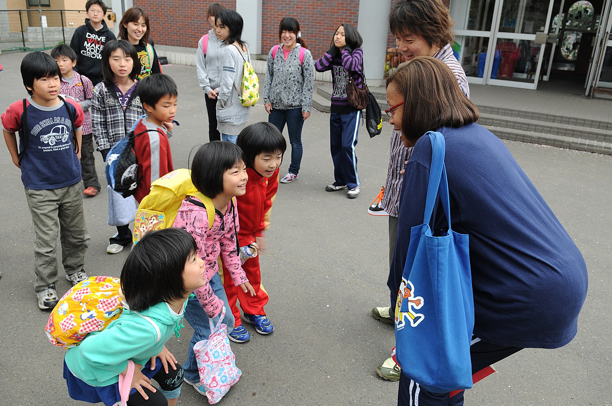 Rhonda Jackson, (right) Misawa Air Base’s Sollars Elementary School speech pathologist, teaches Japanese children from Shichinohe Bikoh-En orphanage a song before boarding a bus to Misawa Air Base, May 8. The school’s student counsel program hosted a sport’s day exchange event to integrate American and Japanese culture through sporting activities. (U.S. Air Force/ Senior Airman Jessica Lockoski)
